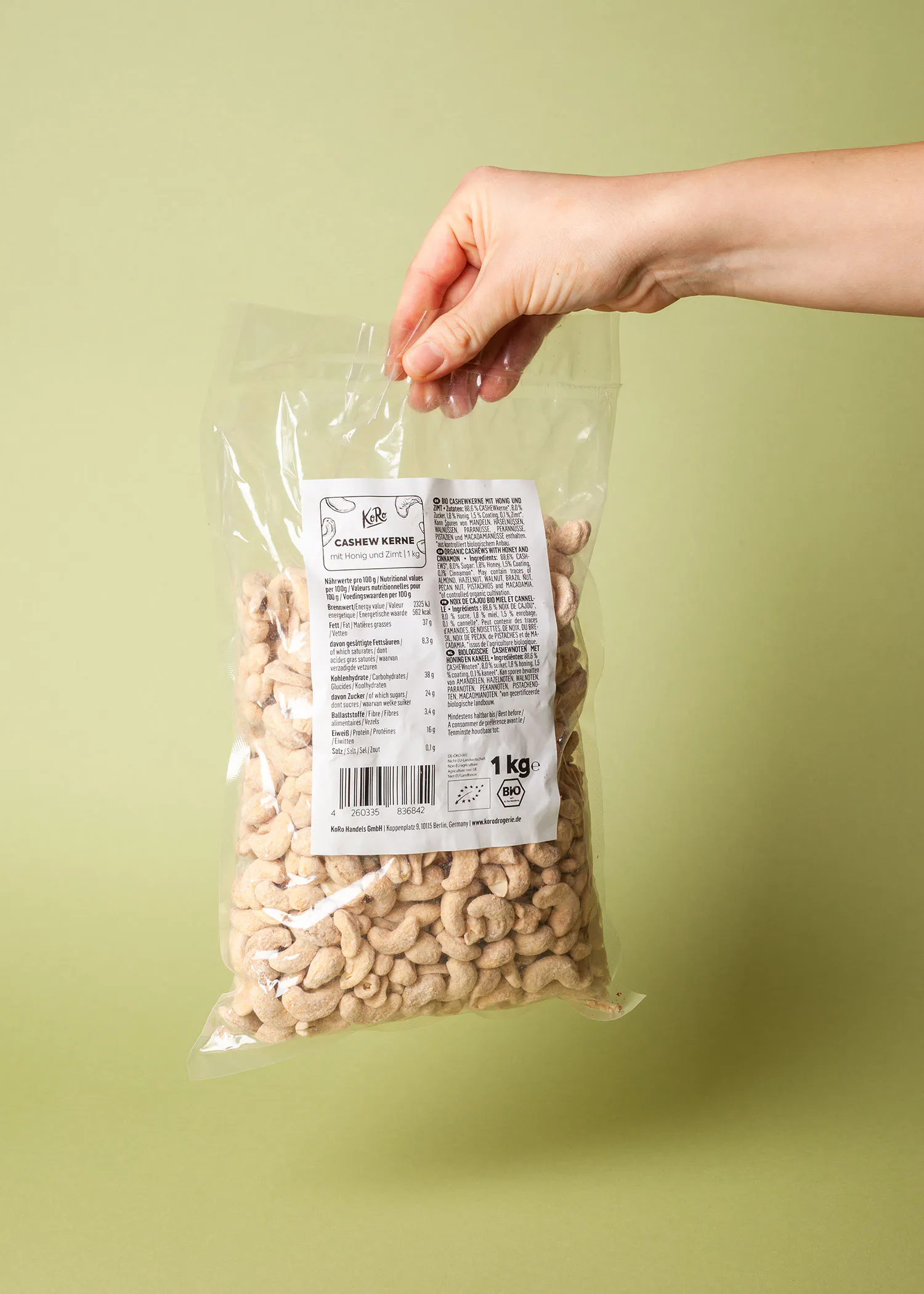 a person is holding a bag of cashews in their hand