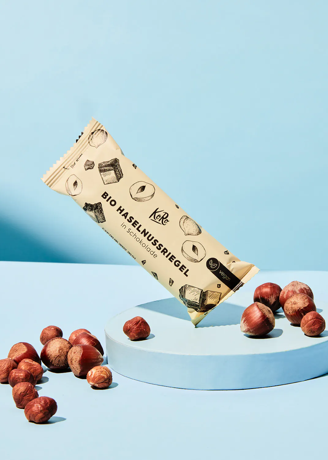 une barre de chocolat bio avec des noisettes à côté