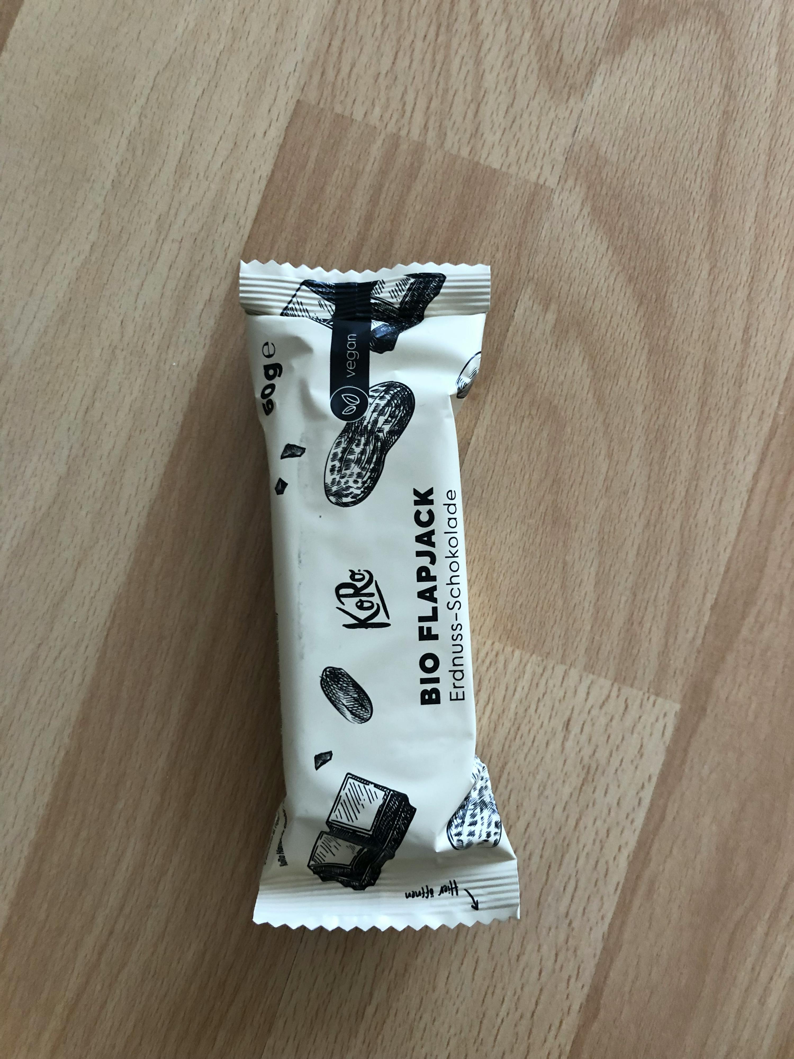 una barretta di cioccolato bio flapjack si trova su un tavolo di legno