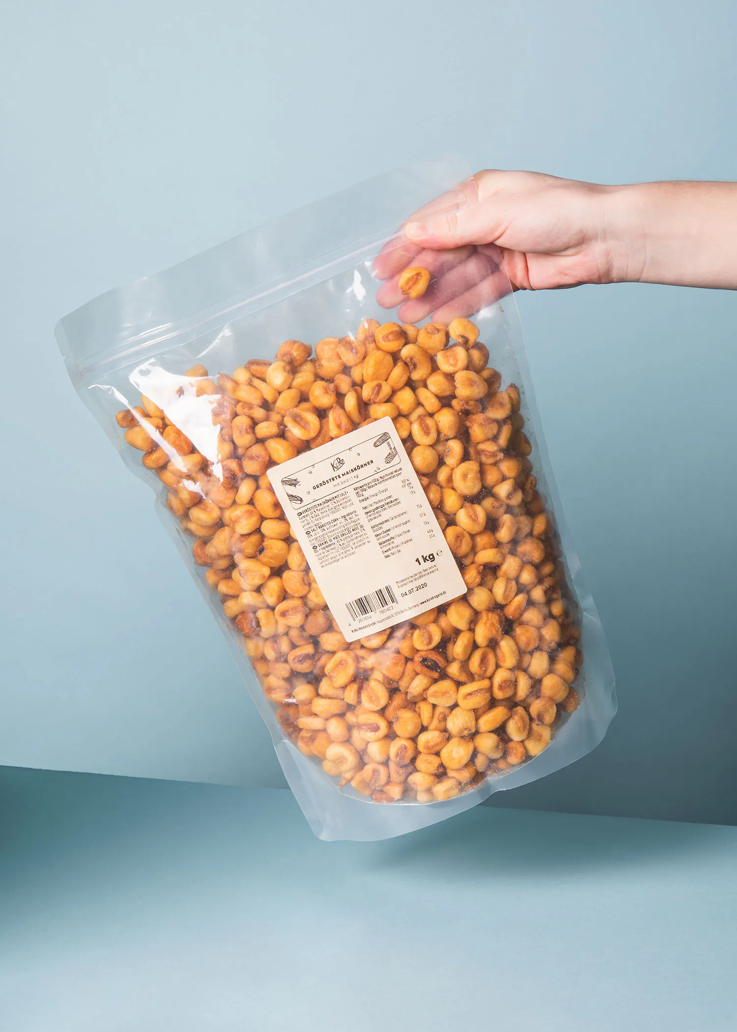 une personne tient un sac en plastique rempli de maïs