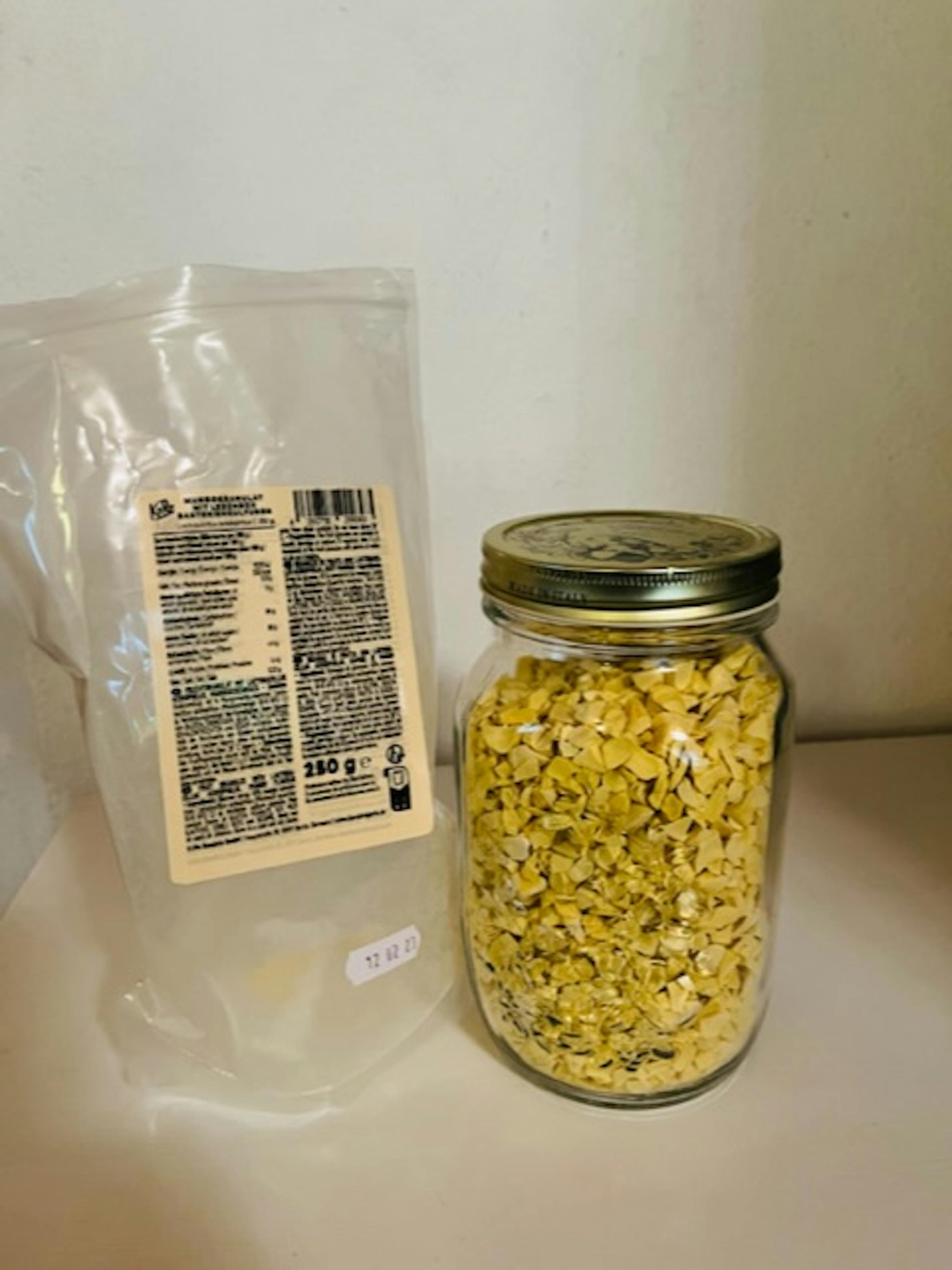 un barattolo di avena è seduto accanto a una busta di avena