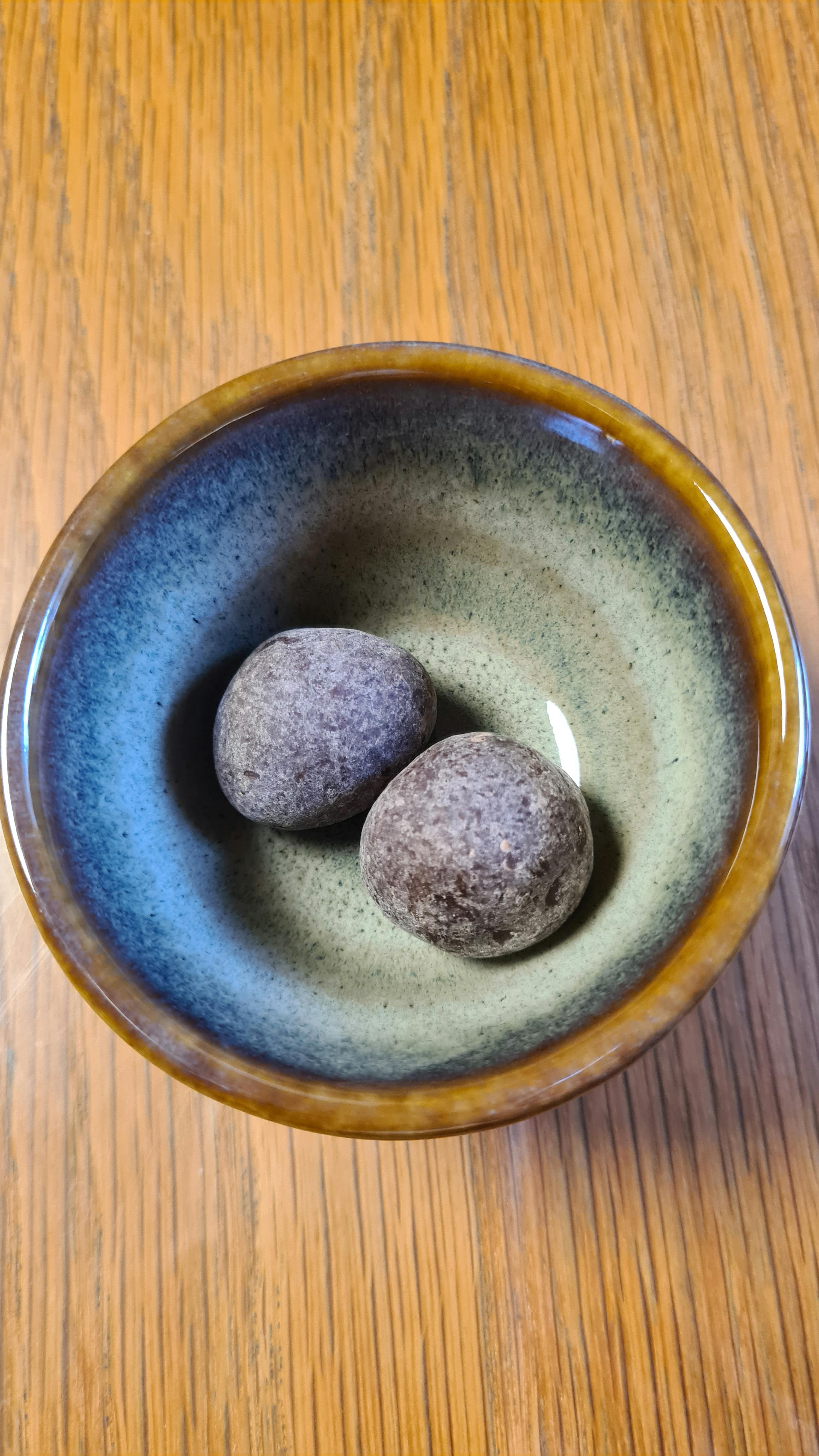 eine blau-braune Schale mit zwei Schokoladenkugeln darin
