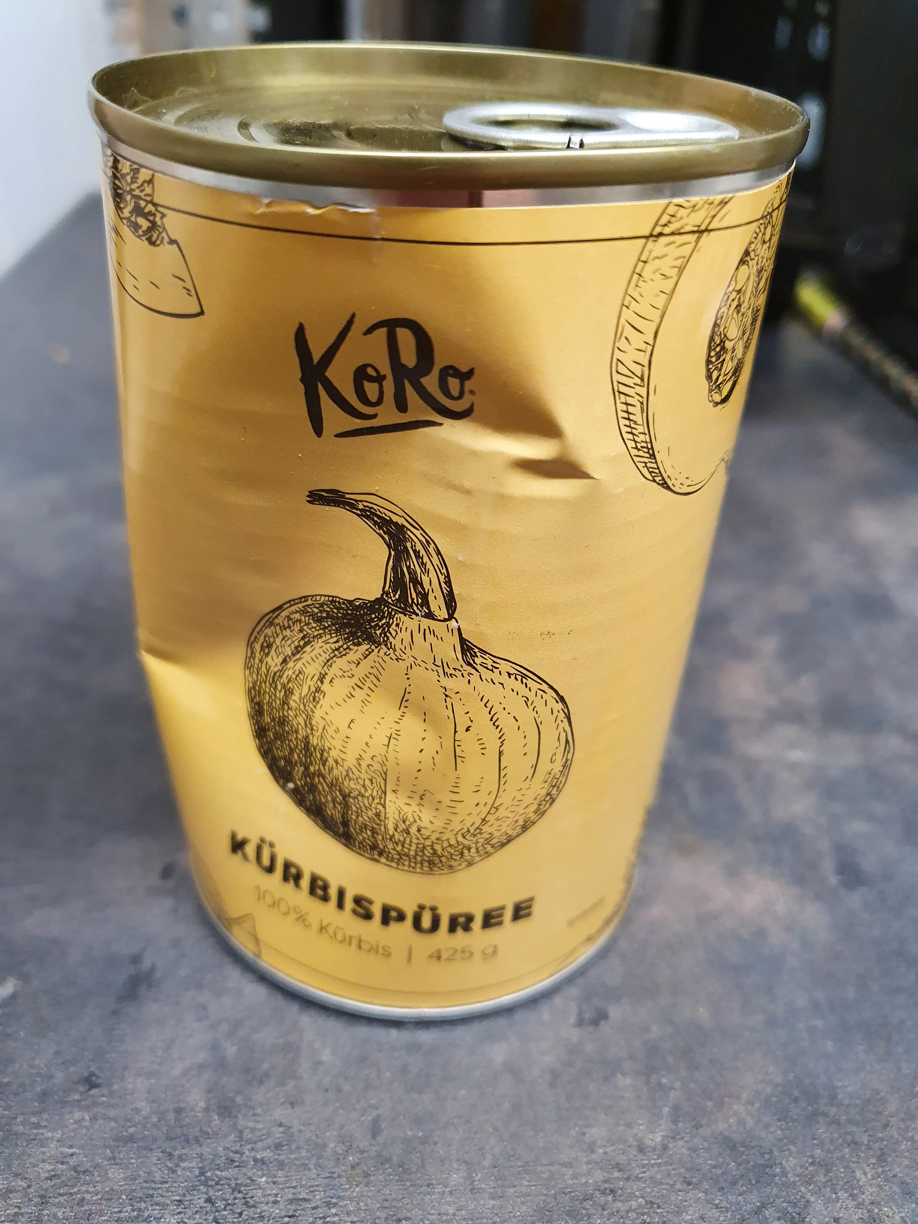 eine Dose Kürbispüree mit einem Kürbis darauf