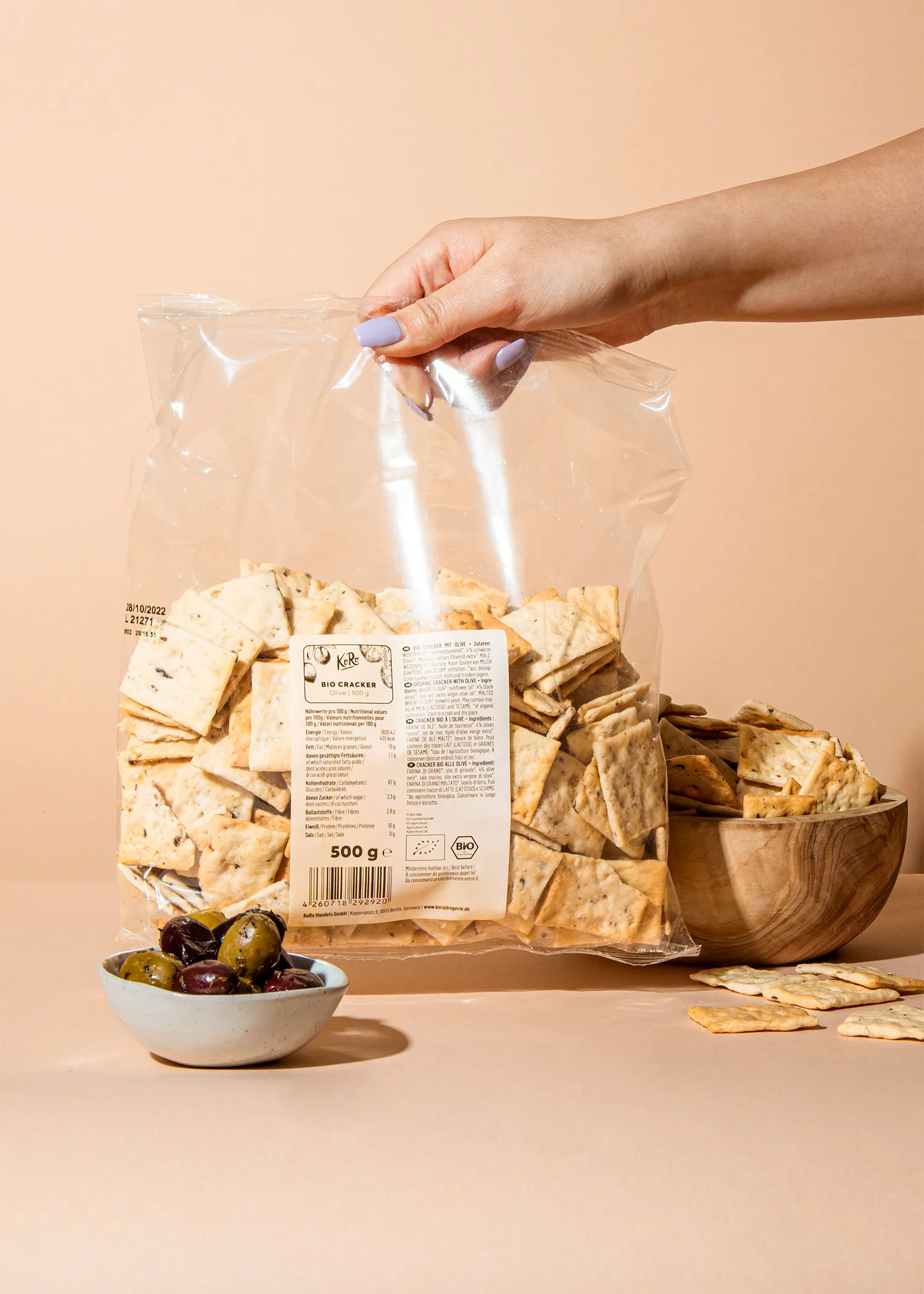 eine Person hält einen Plastikbeutel mit Crackern in der Hand