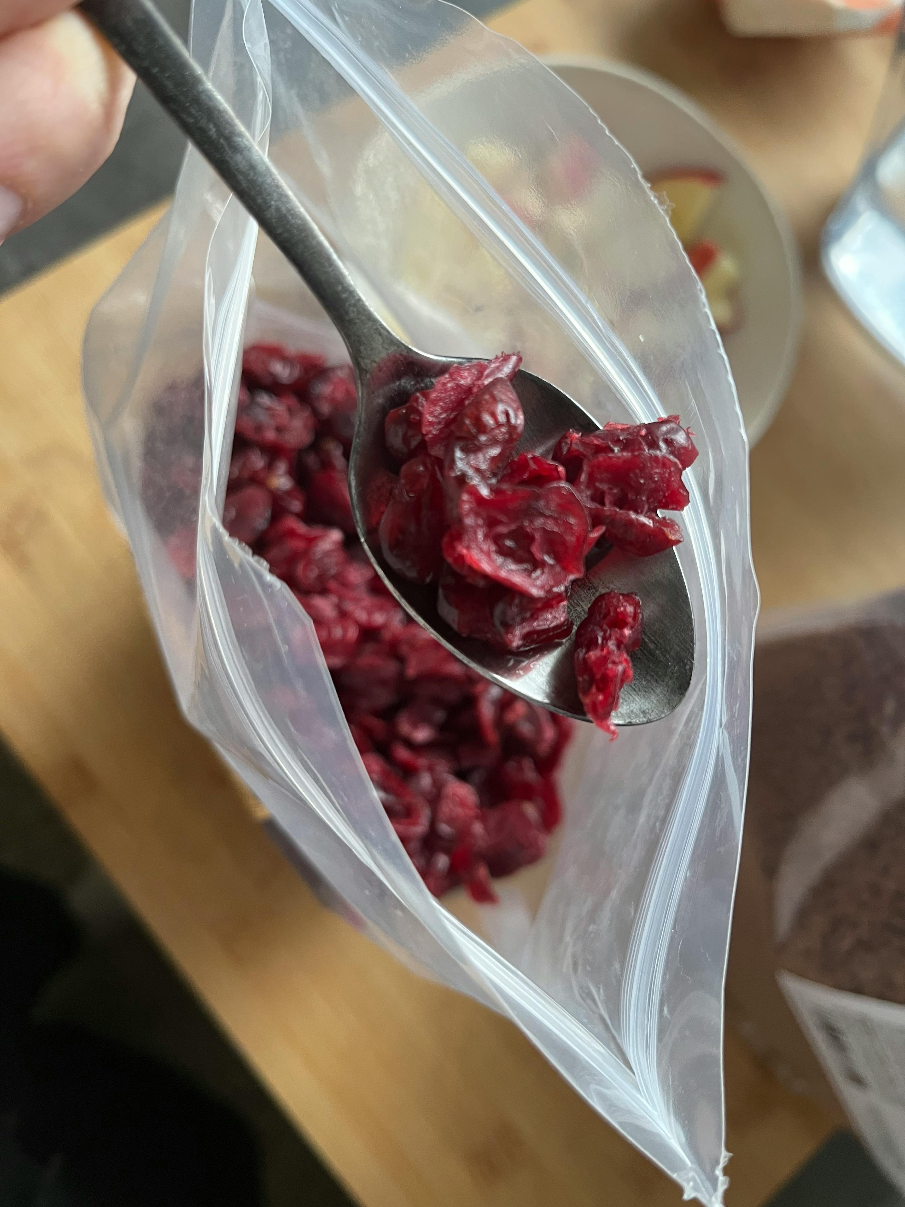 a bag of cranberries with a spoon in it