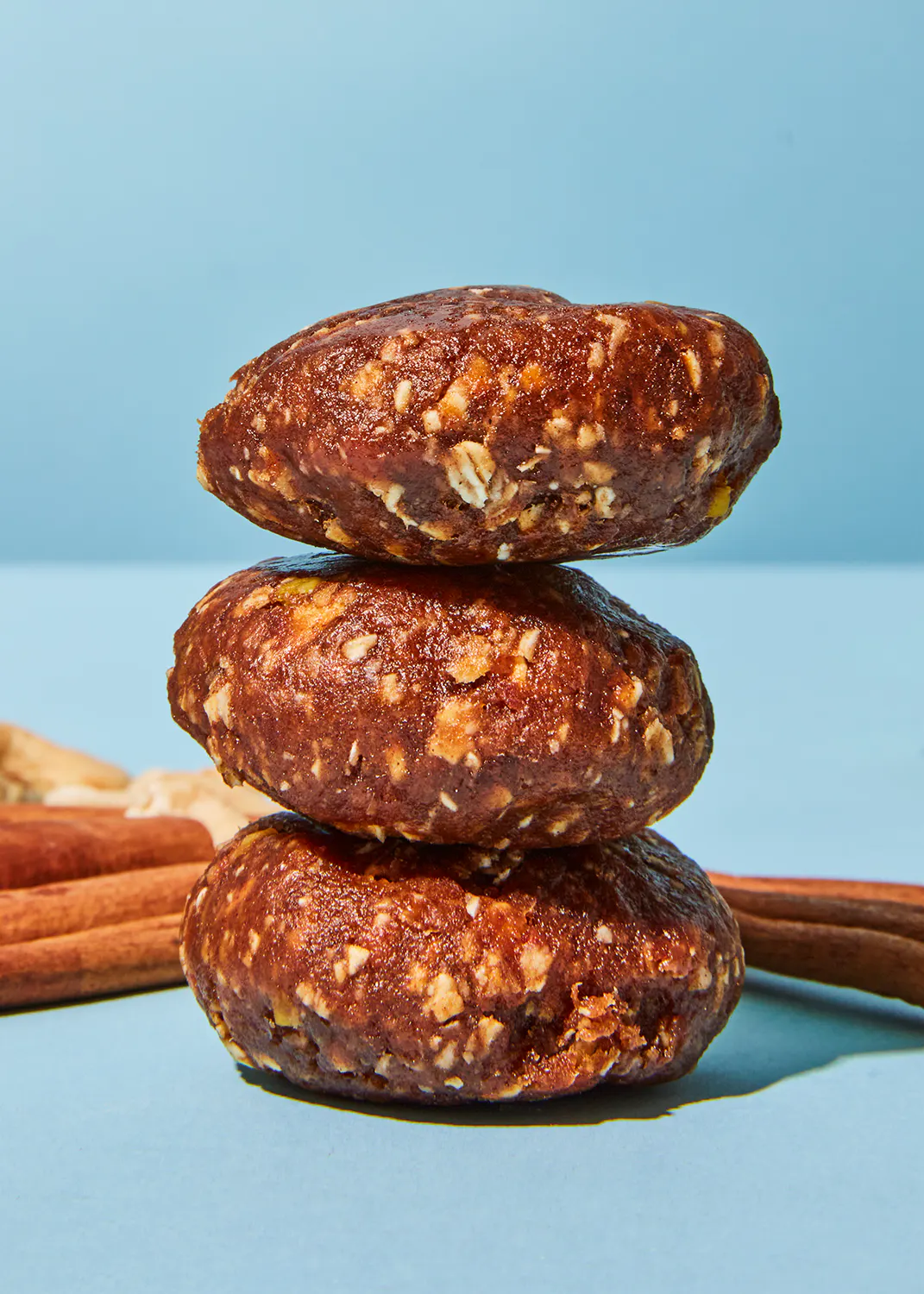 drei Schokoladenkeks stapeln sich aufeinander auf einem blauen Tisch