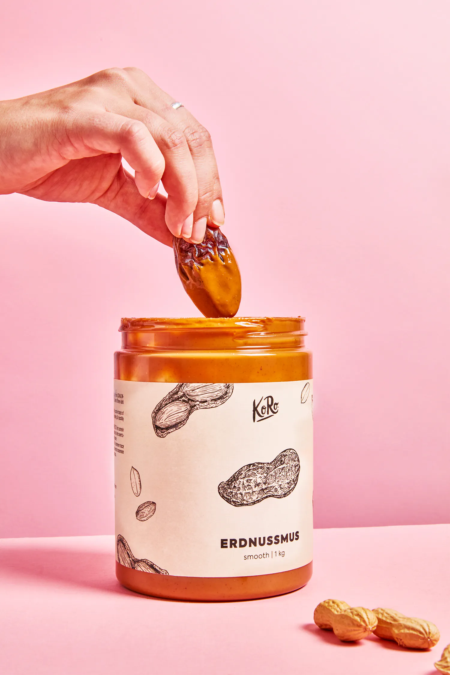 une personne verse un morceau de beurre d' arachide dans un bocal