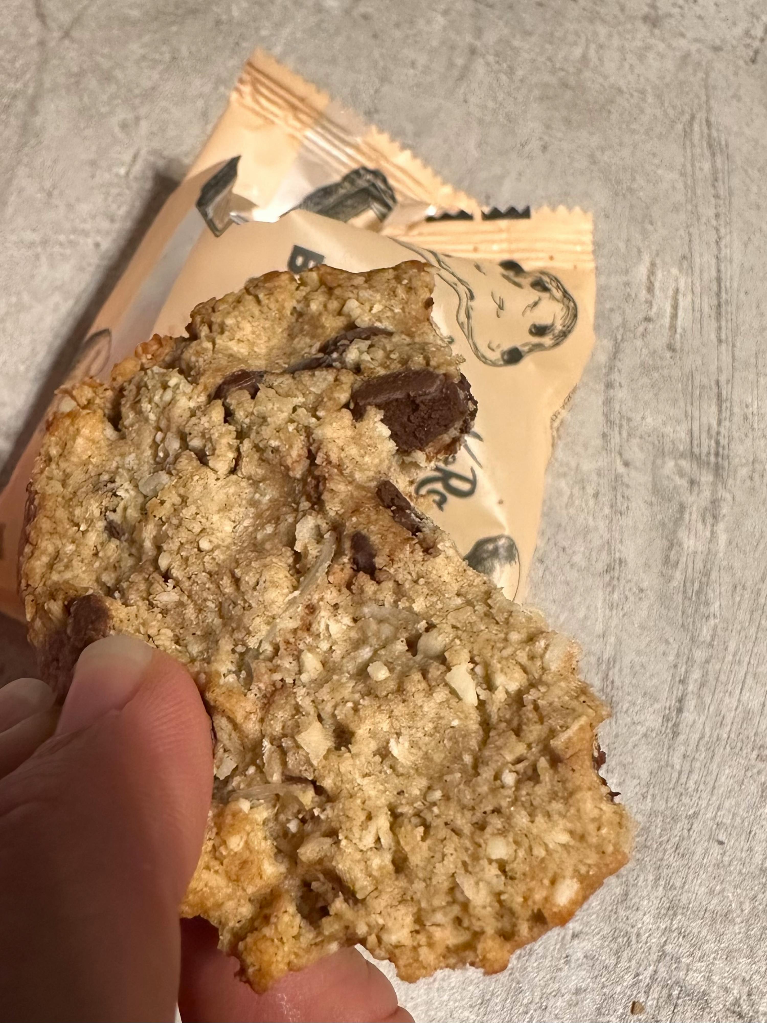 eine Person hält einen Keks mit Schokoladenstückchen in der Hand