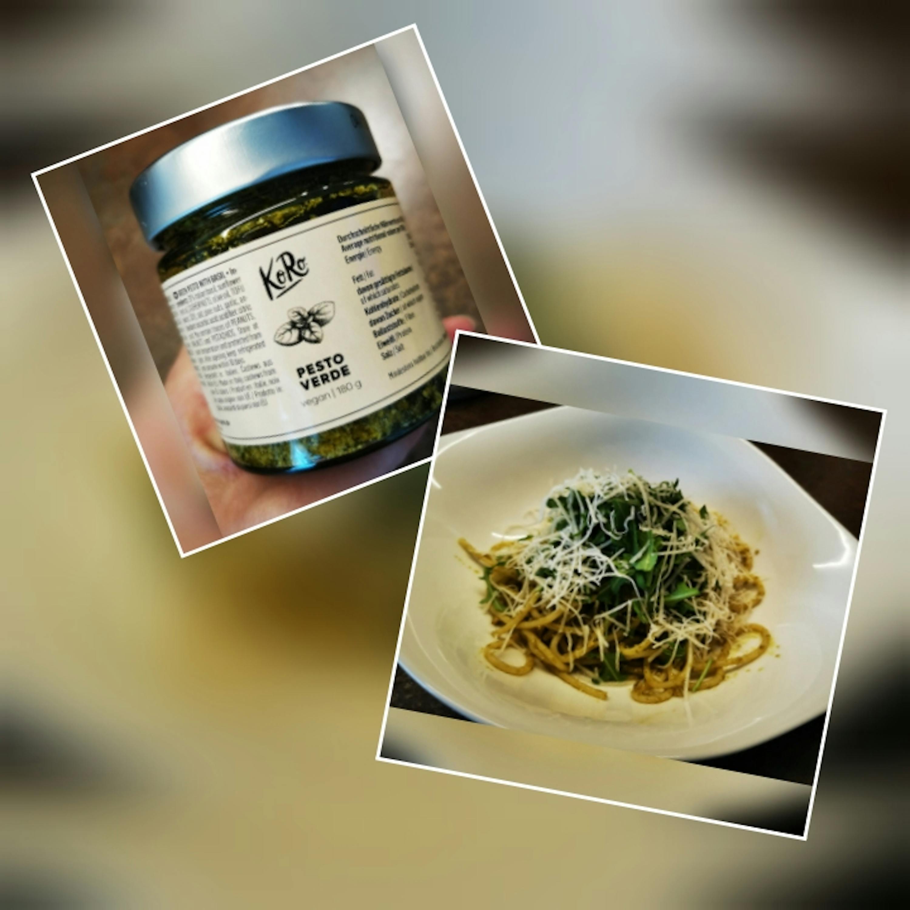 eine Person hält eine Dose pesto verde neben einem Teller Nudeln