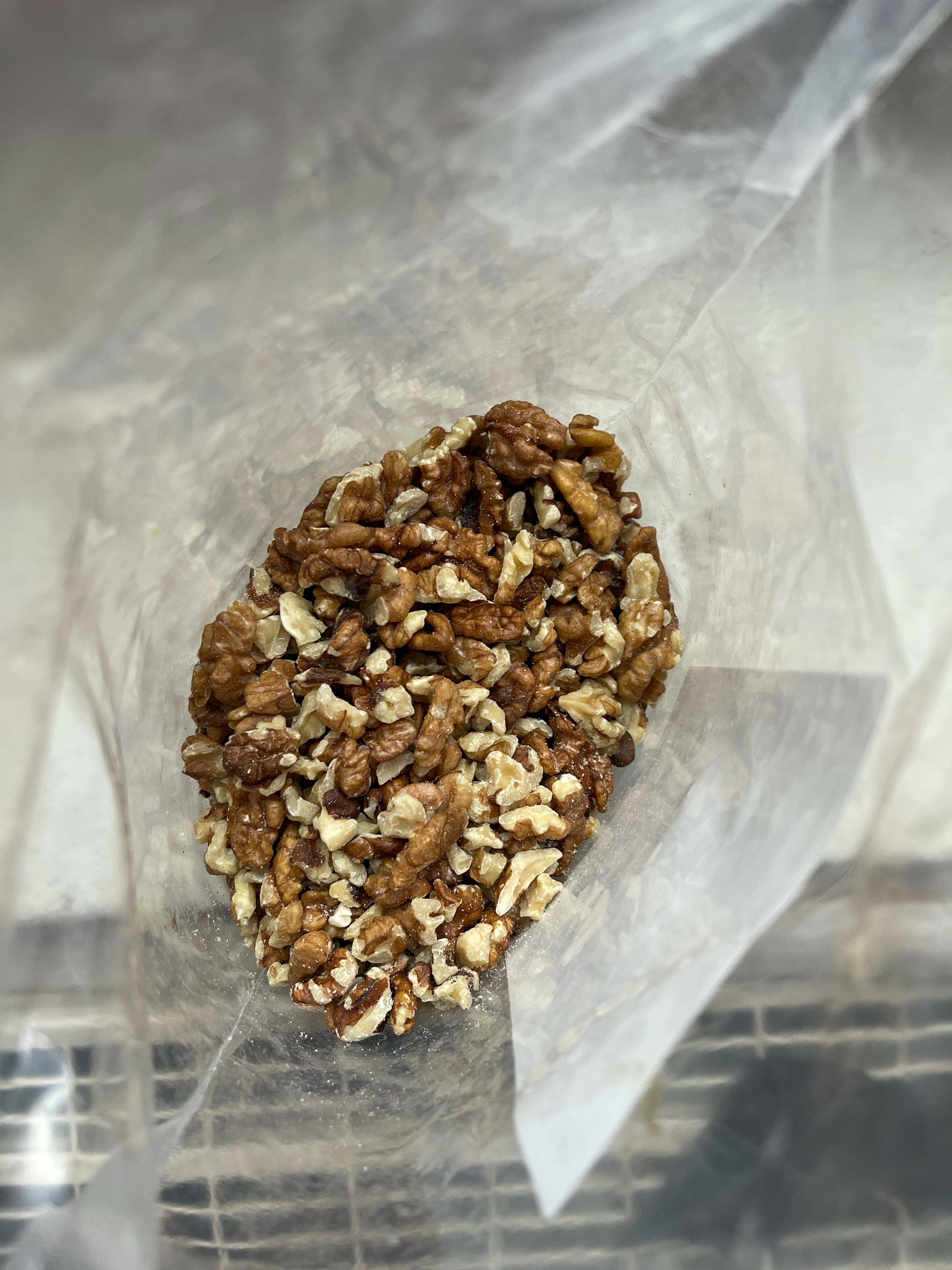 un sac en plastique rempli de noix est posé sur une table