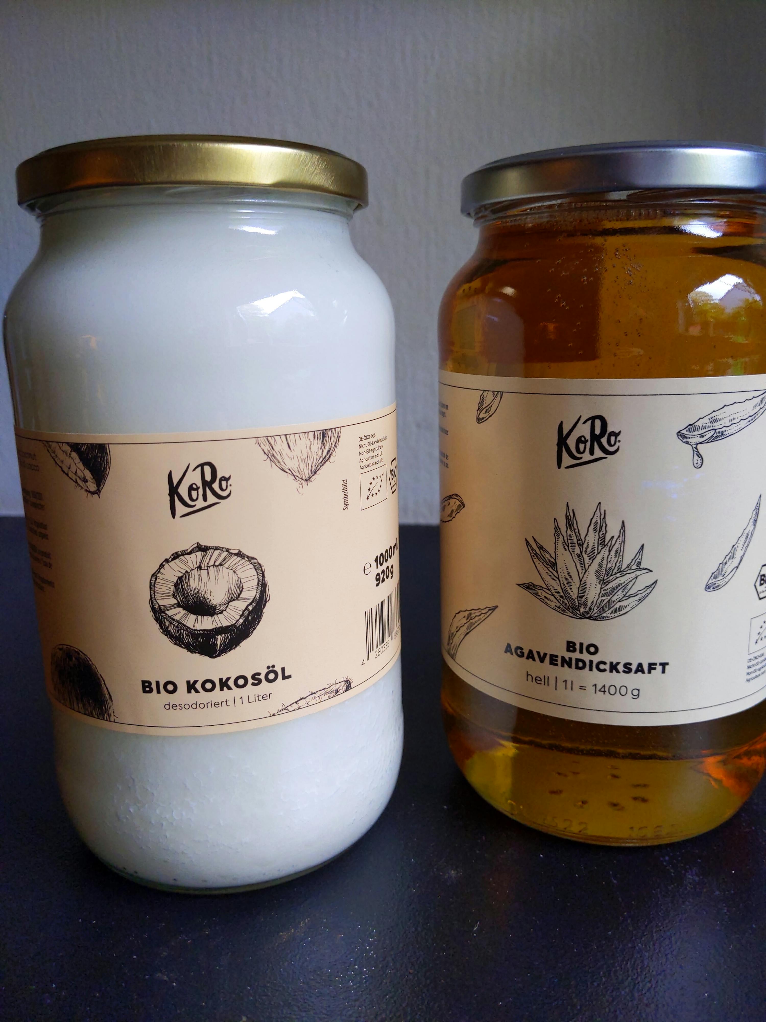 un barattolo di olio di cocco e un barattolo di miele sono su un tavolo