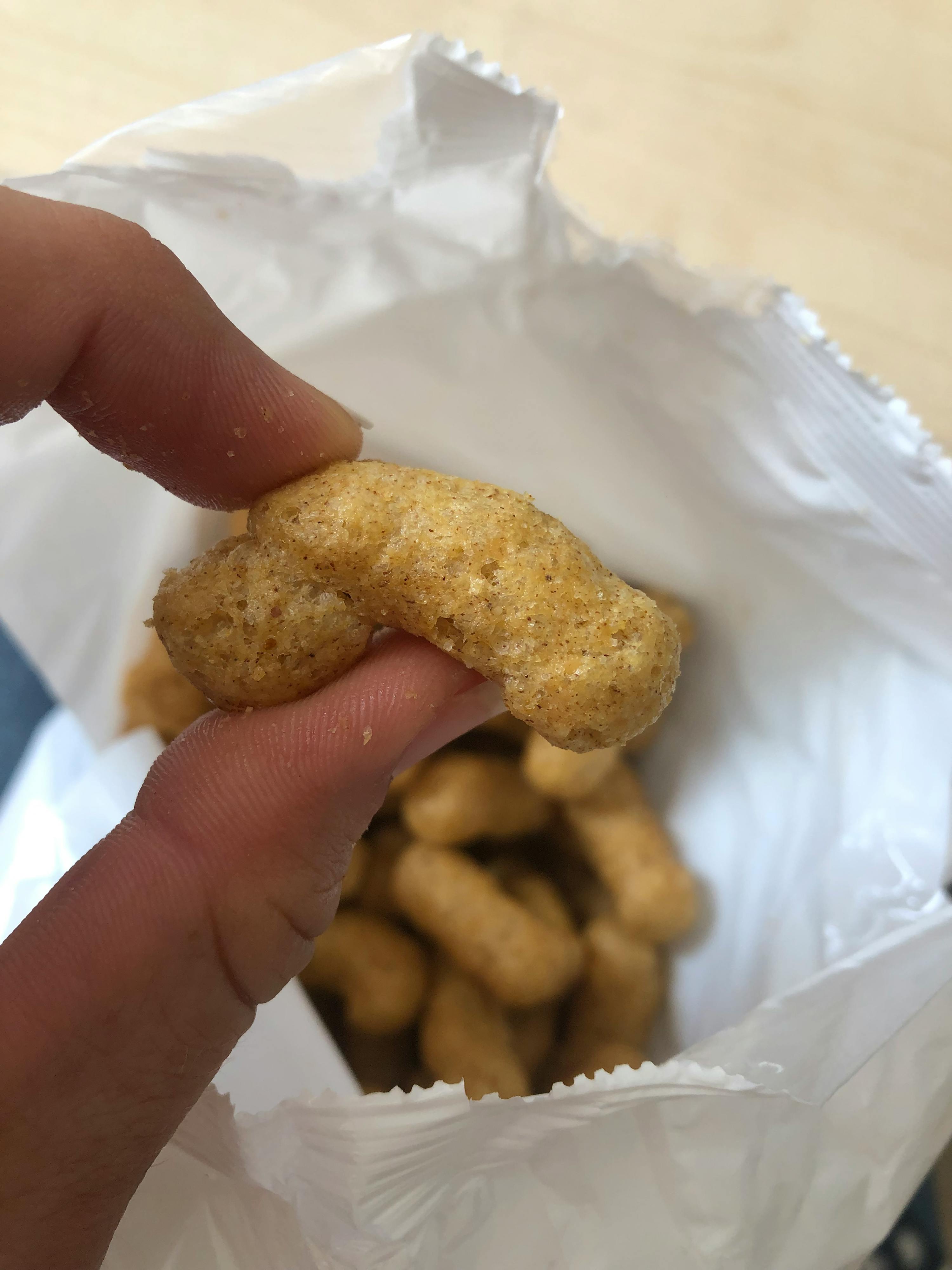 eine Person hält einen Cracker in der Hand neben einer Tüte Cracker