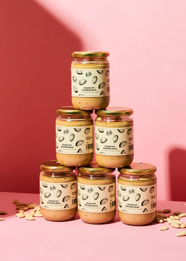 sechs Gläser crunchy mandelmus stehen nebeneinander