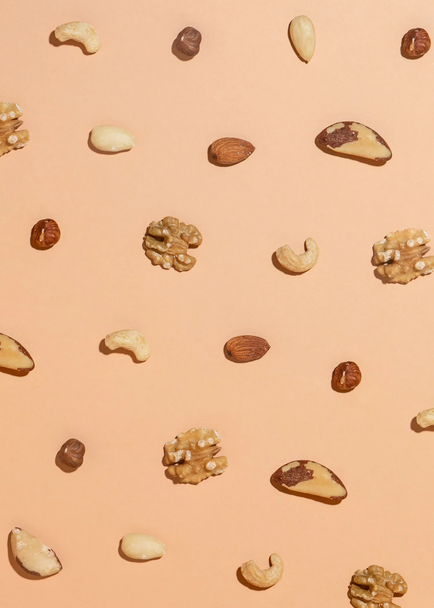 différents types de noix sont disposés sur un fond rose