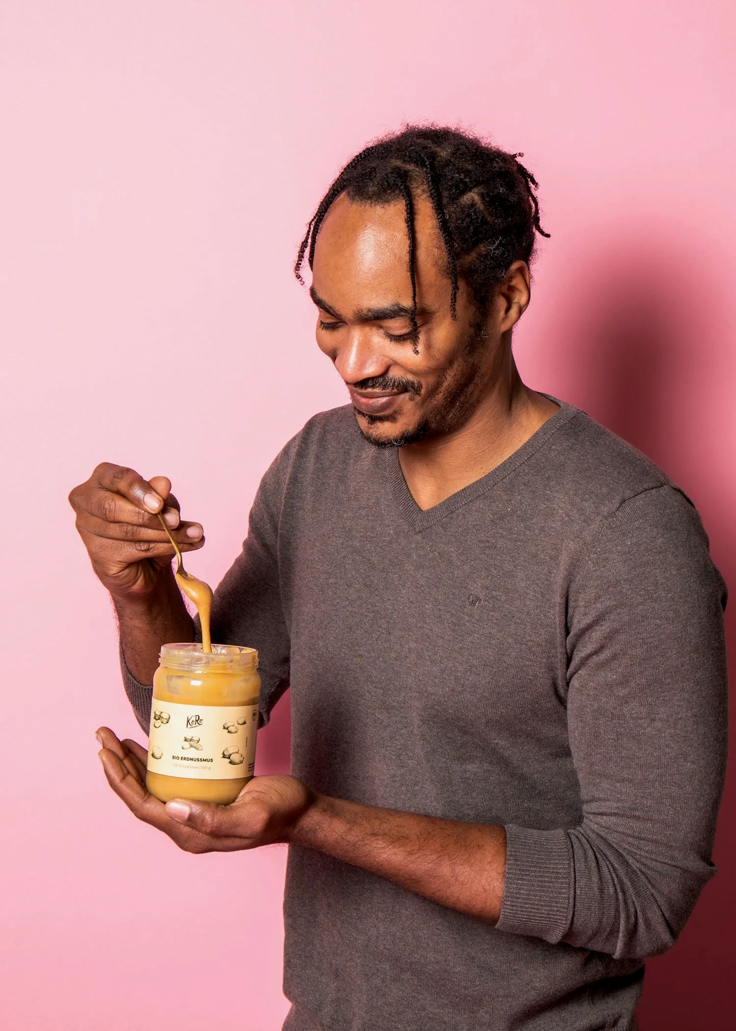 ein Mann hält ein Glas Erdnussbutter in der Hand