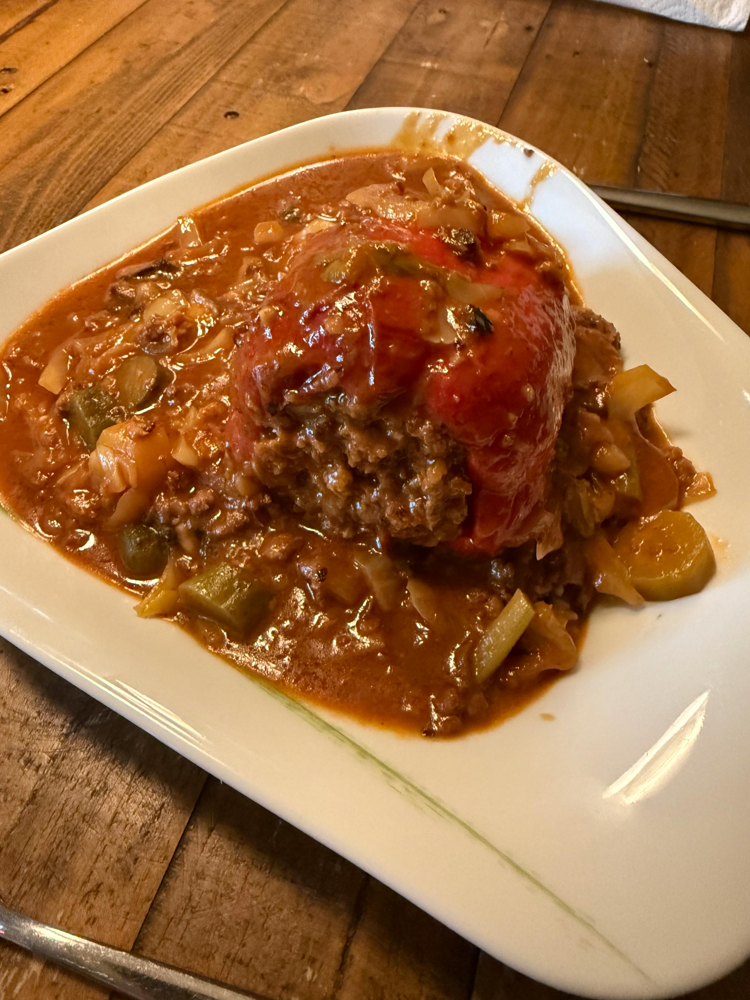 ein weißer Teller mit einem Gemüsegericht auf einem Tisch