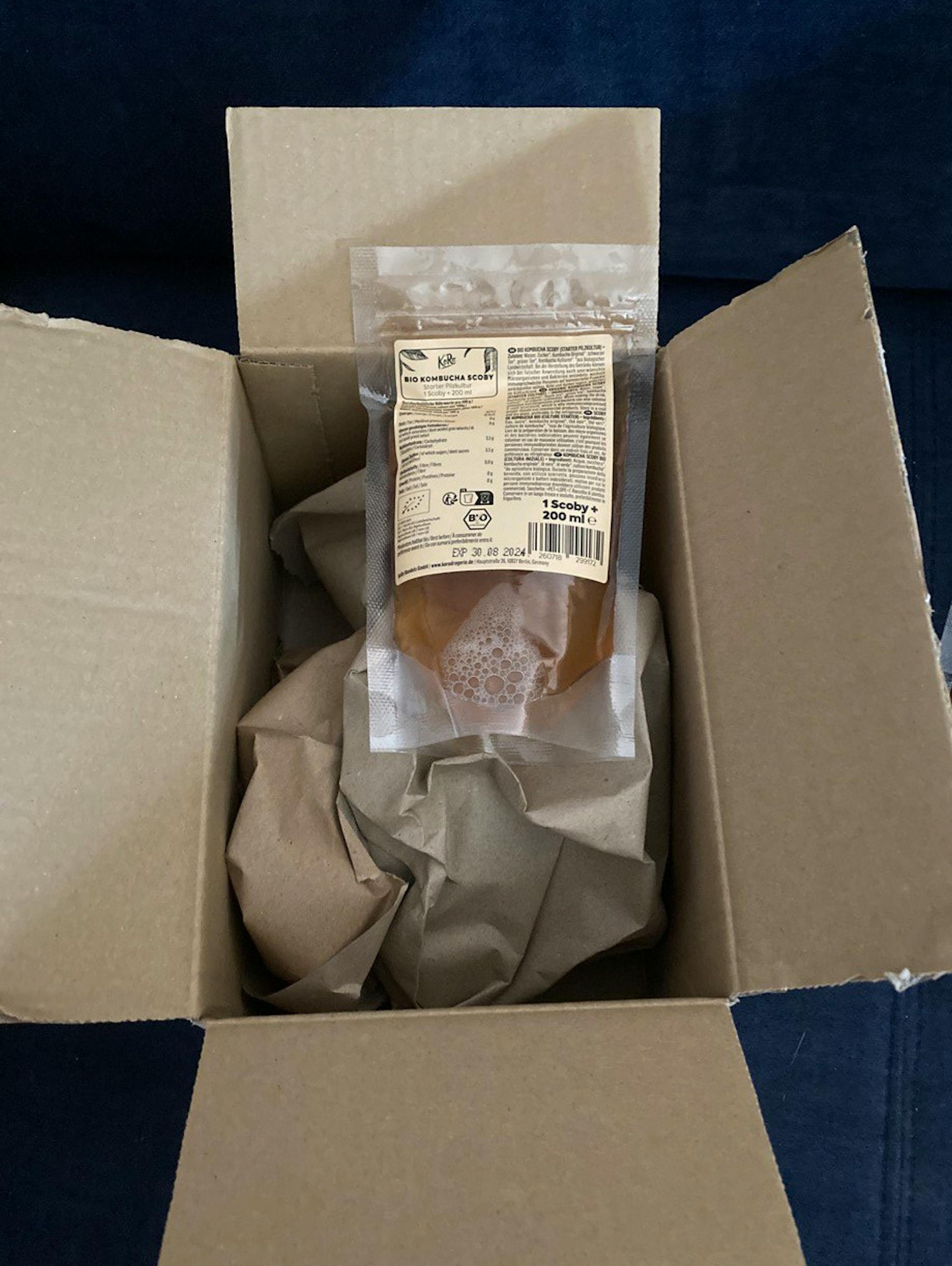 a bag of kombucha sits in a cardboard box