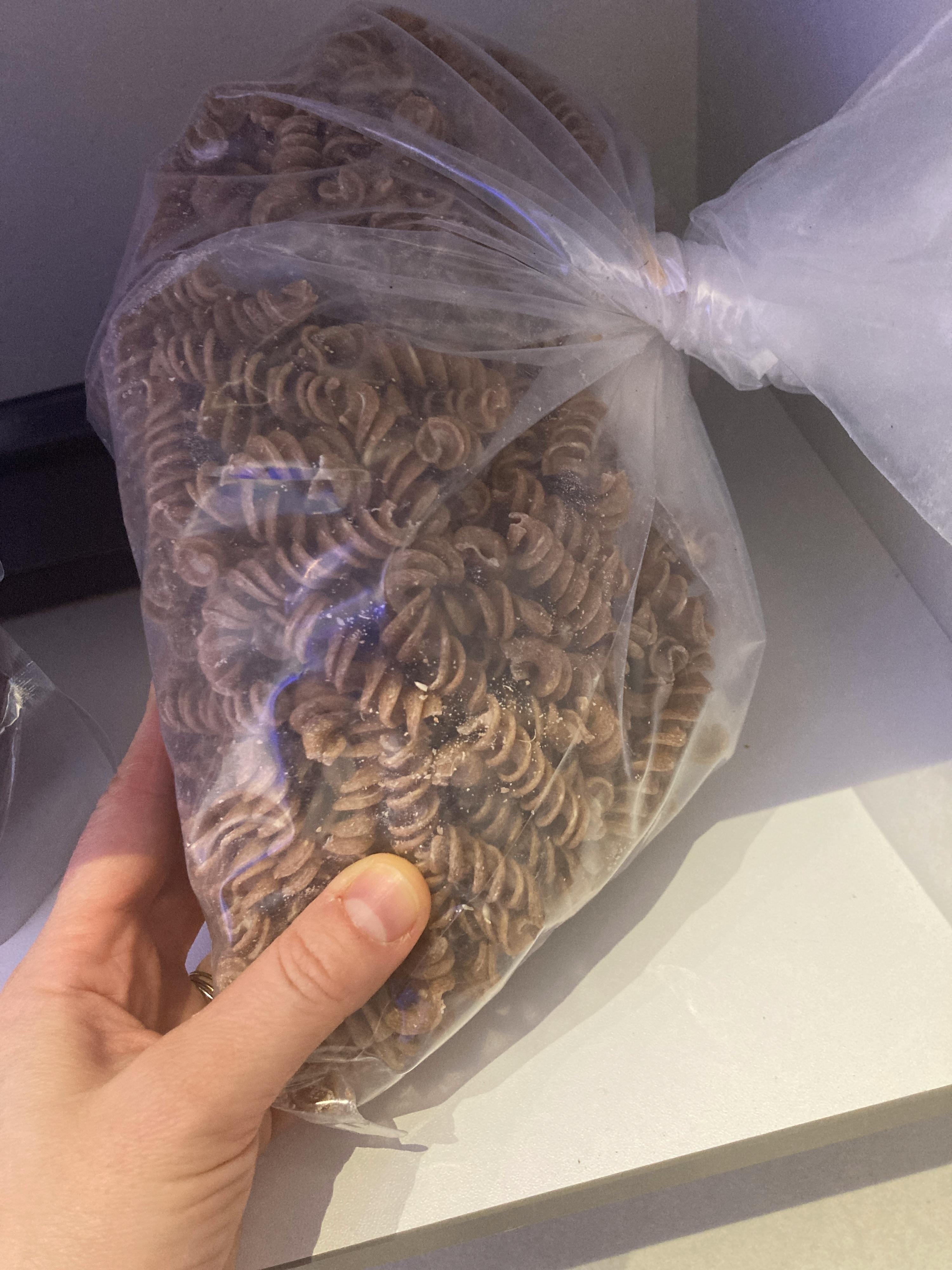 eine Person hält eine Tüte Nudeln in der Hand