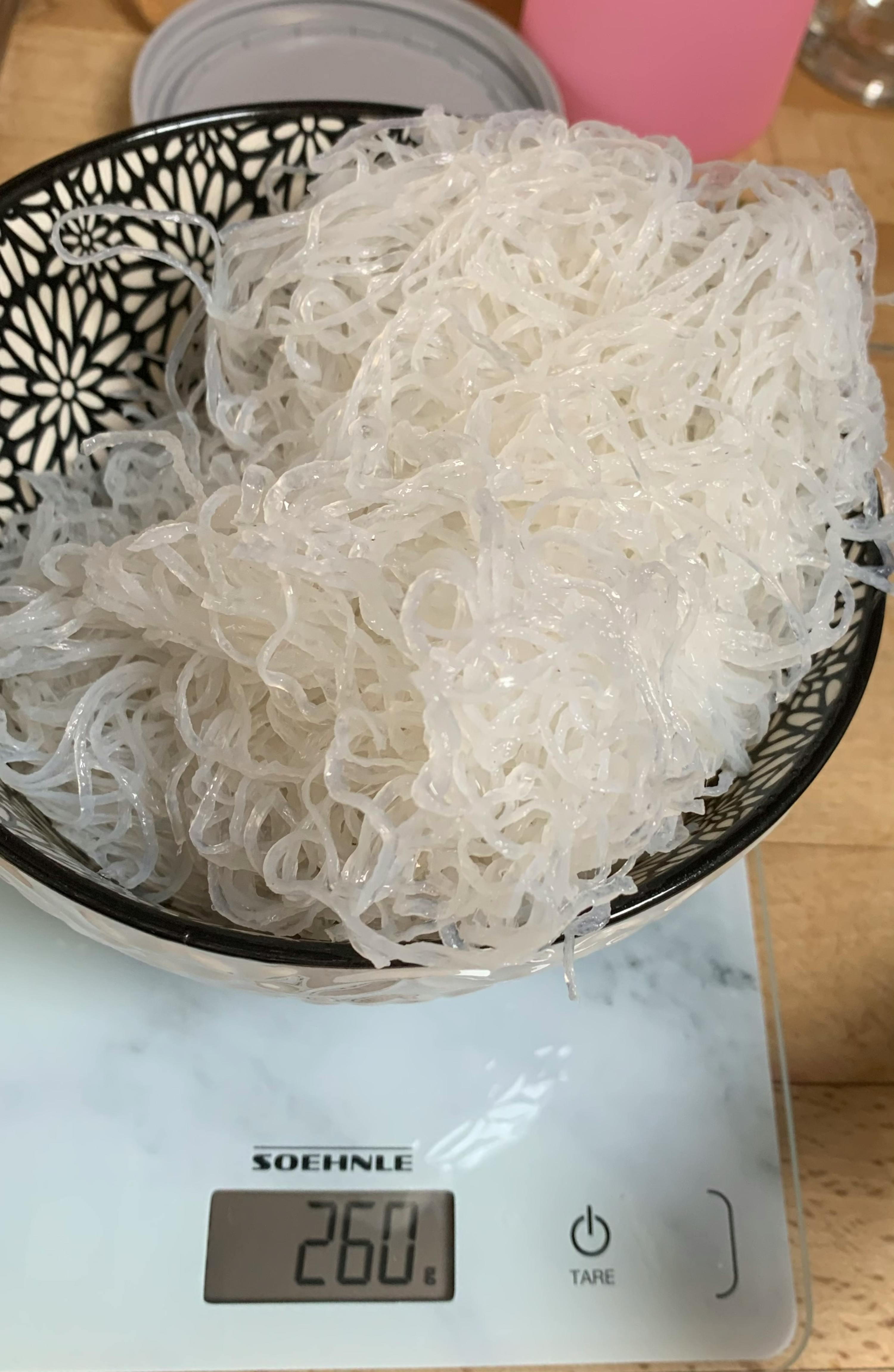 a bowl of noodles is on a soehnle scale