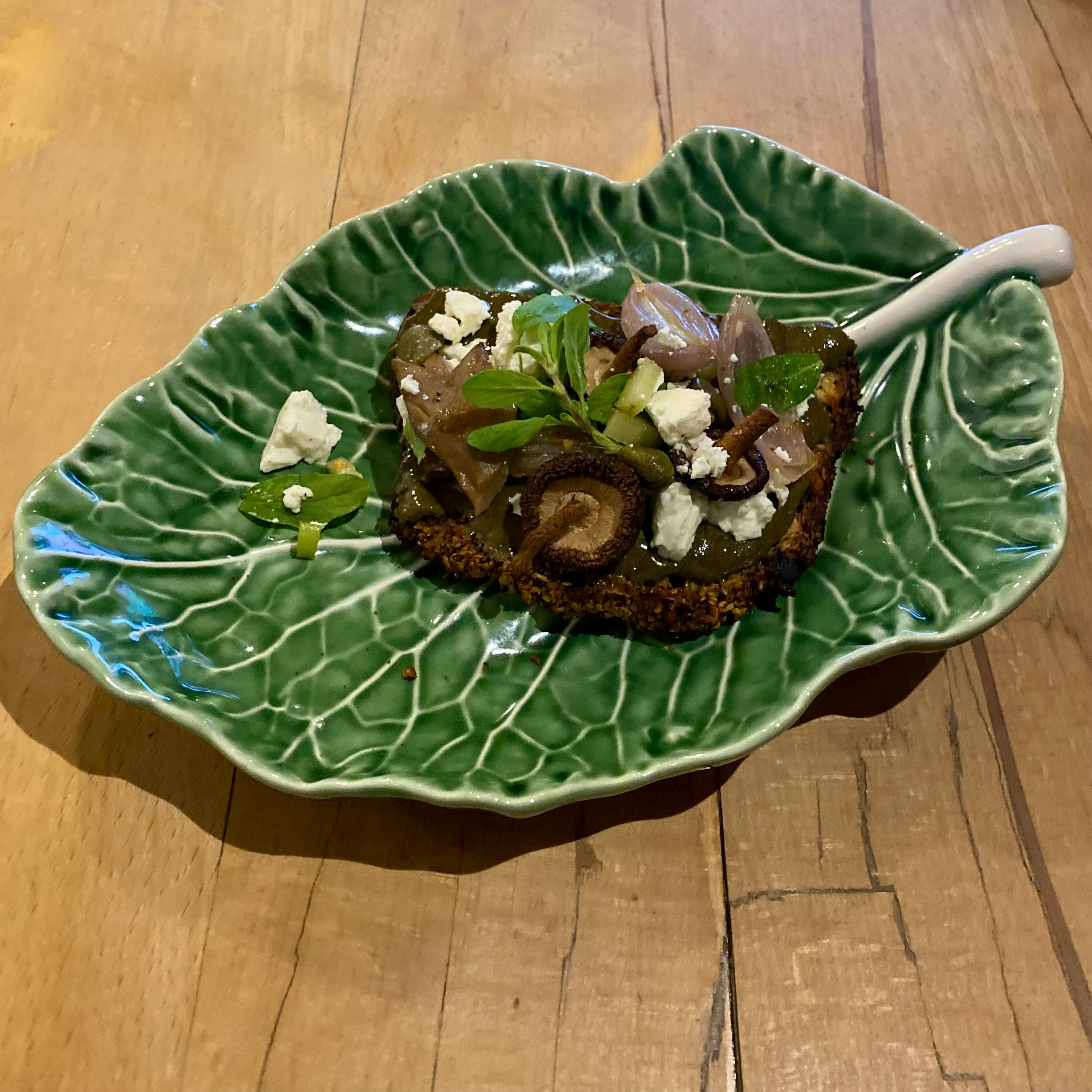 a green leaf shaped plate with food on it
