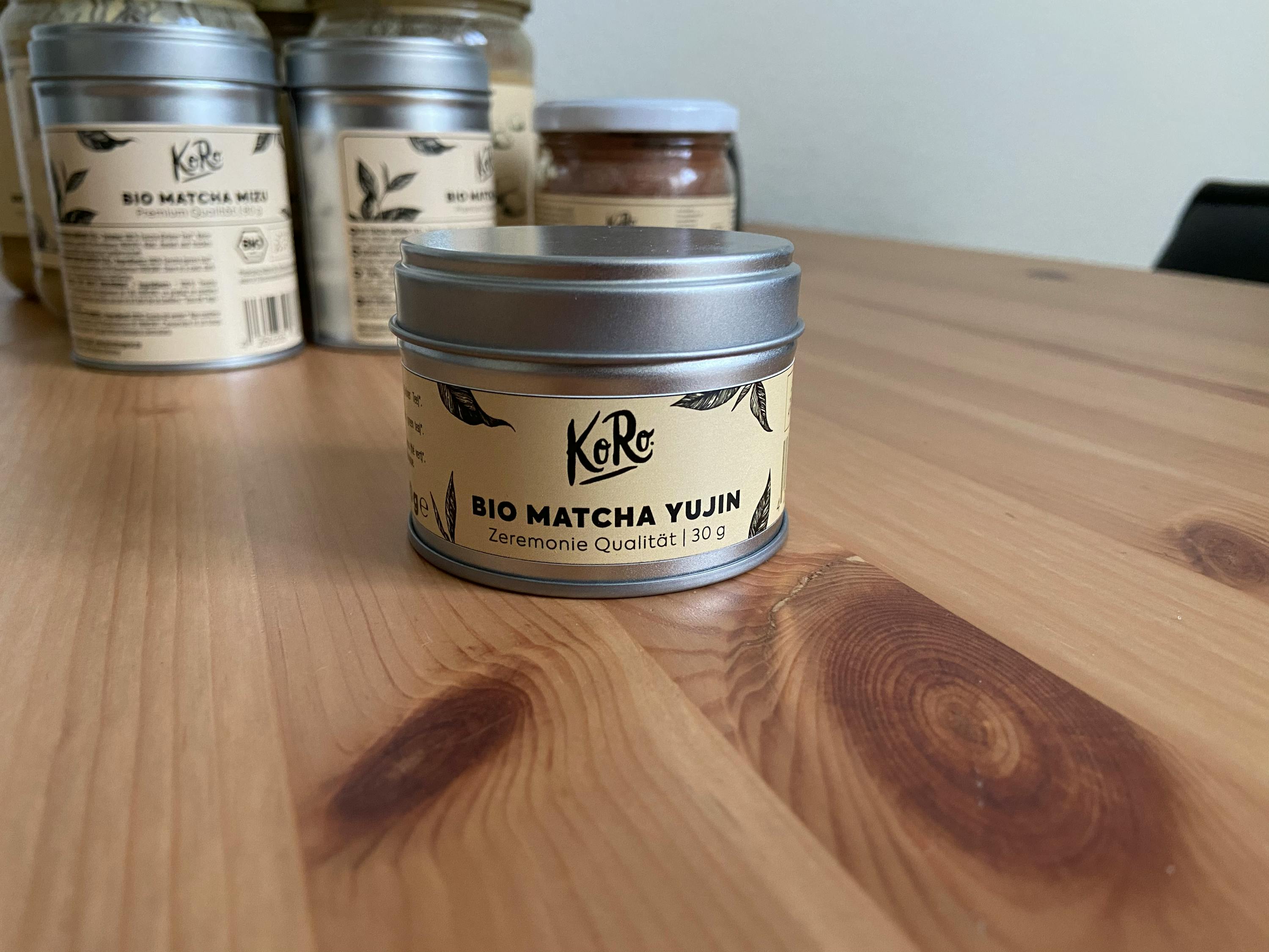 a can of bio matcha yujin is on a wooden table