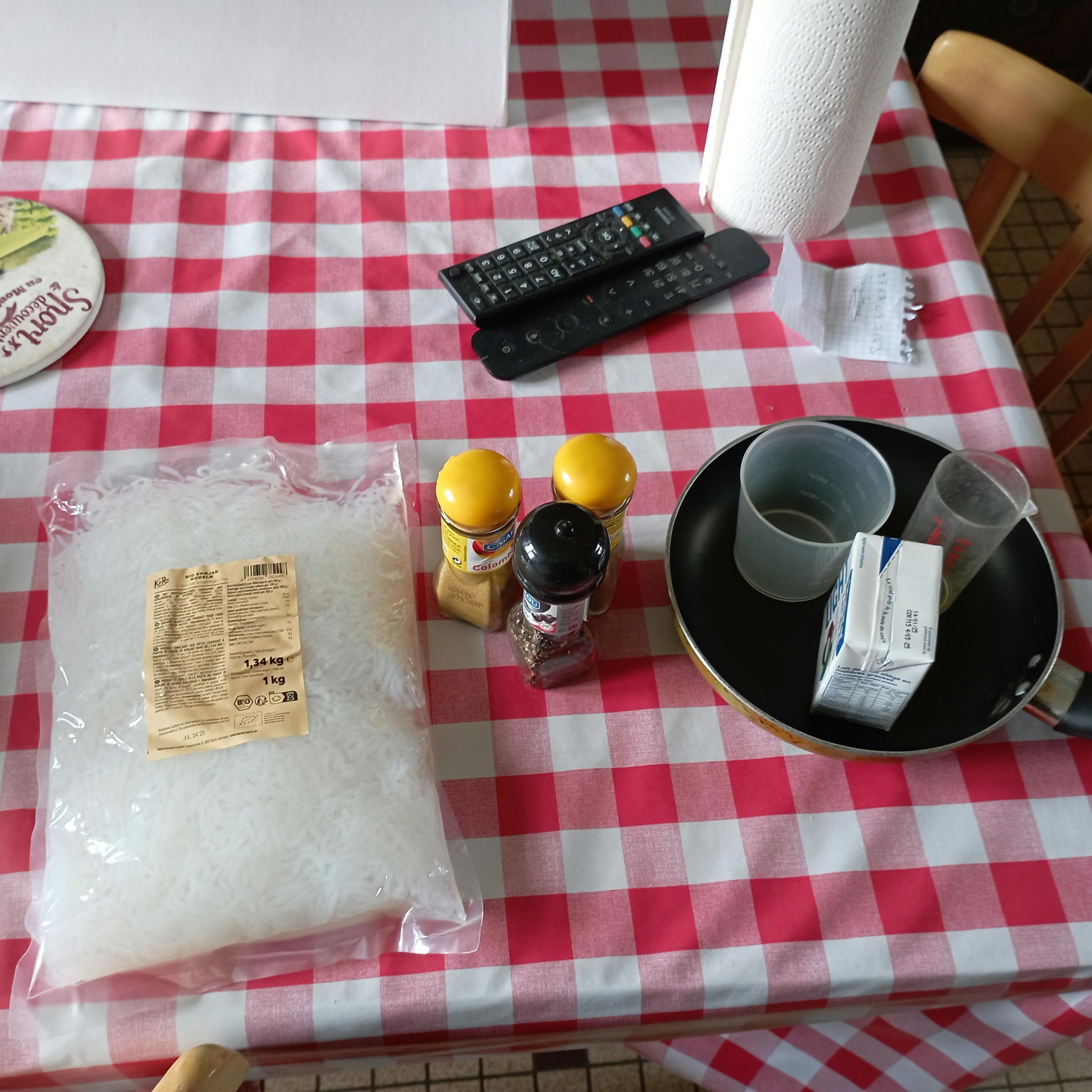 a red and white checkered table cloth with a bag of noodles on it