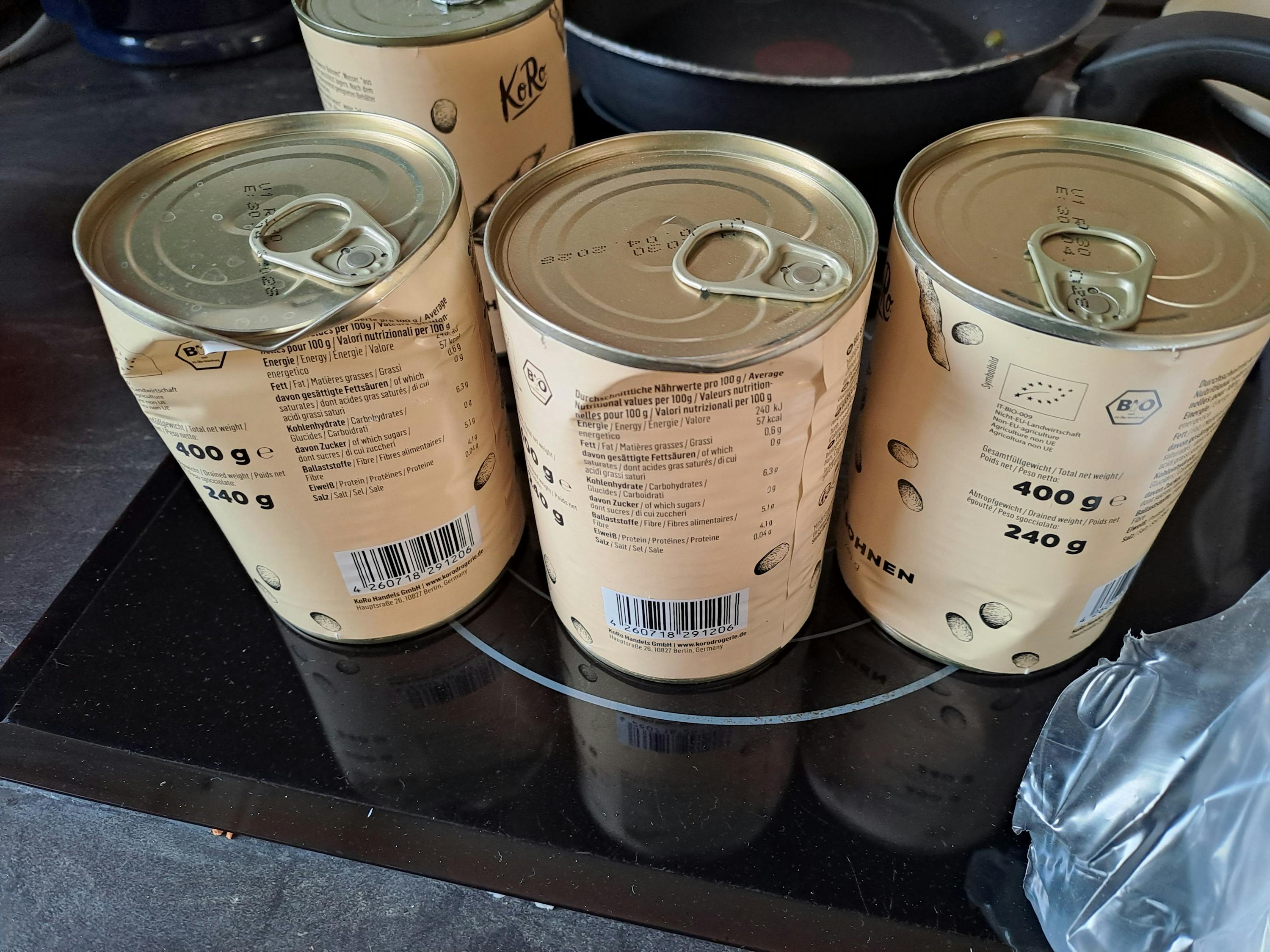 quattro lattine di cibo sono impilate una sopra l' altra su un tavolo