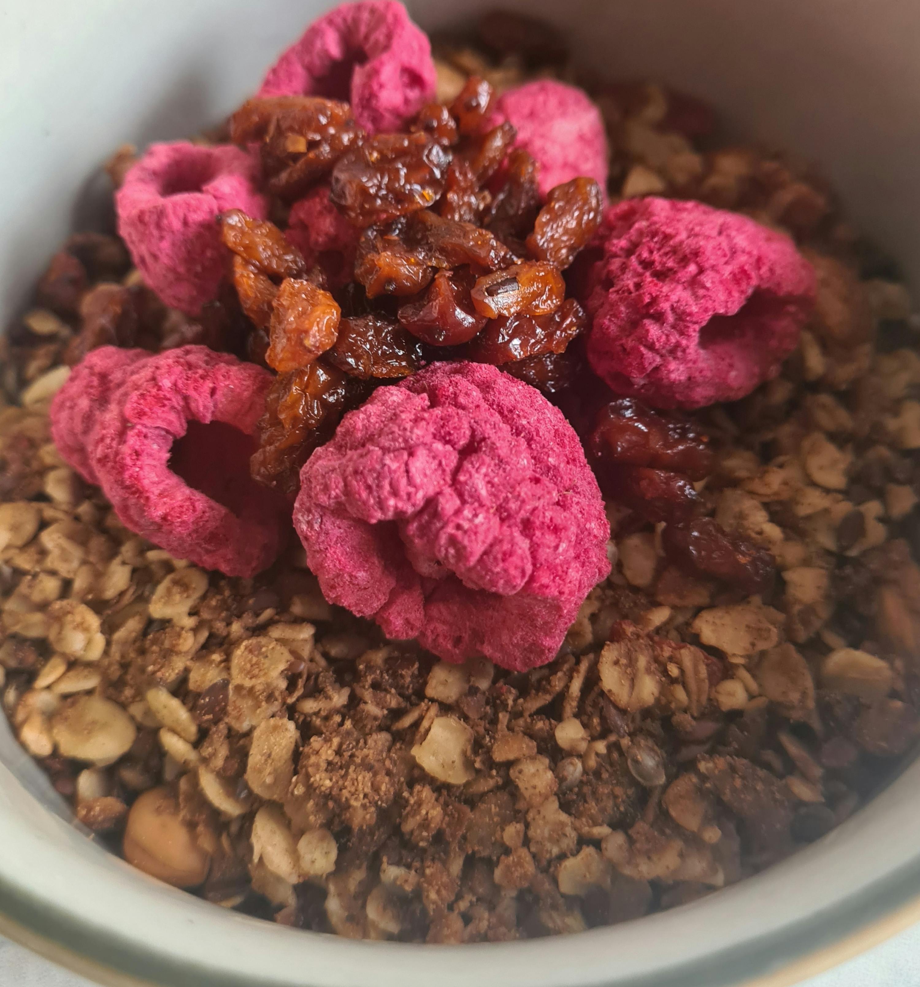 eine Schüssel Müsli mit getrockneten Himbeeren und Rosinen