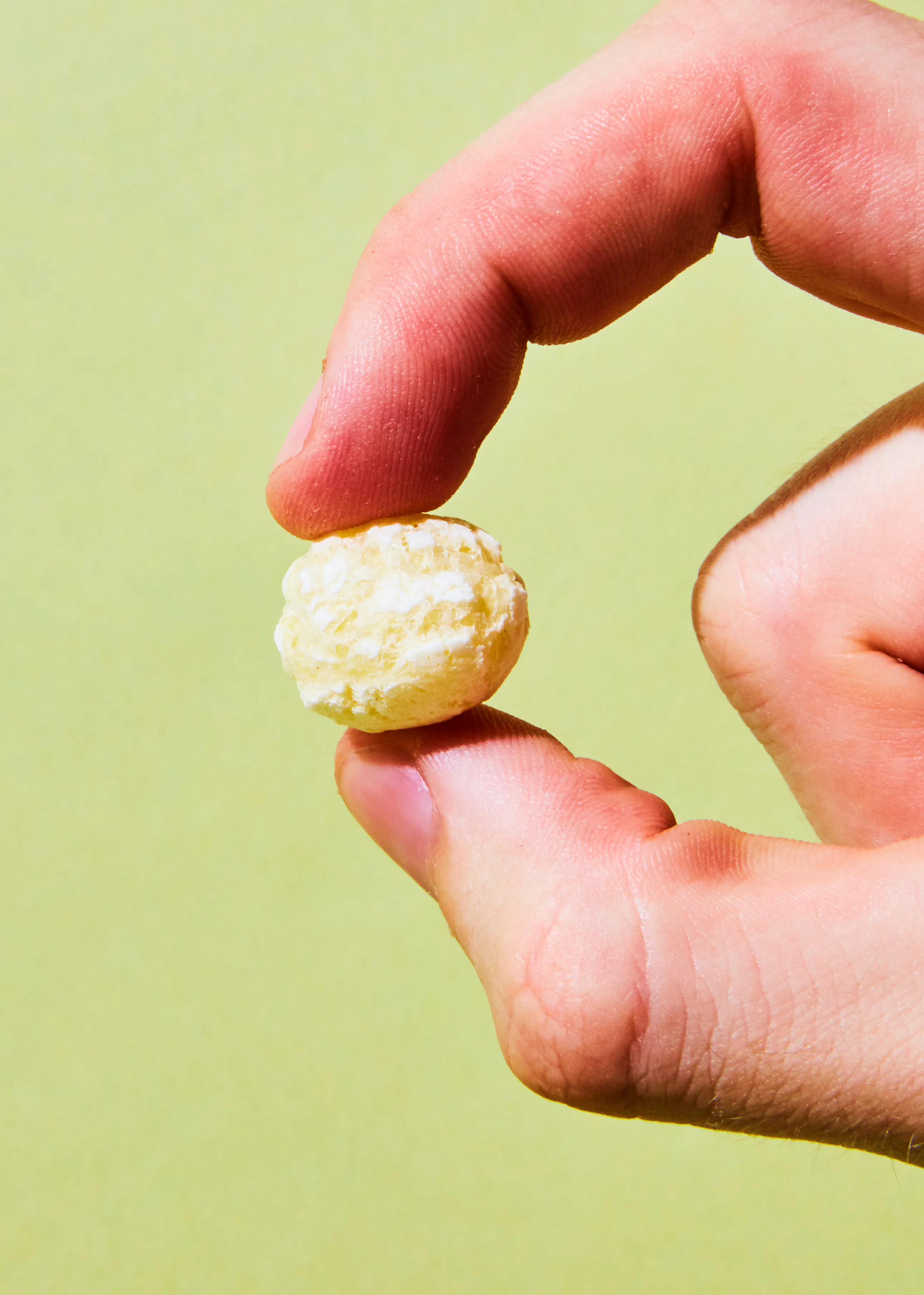 un gros plan d' une main tenant un morceau de nougat