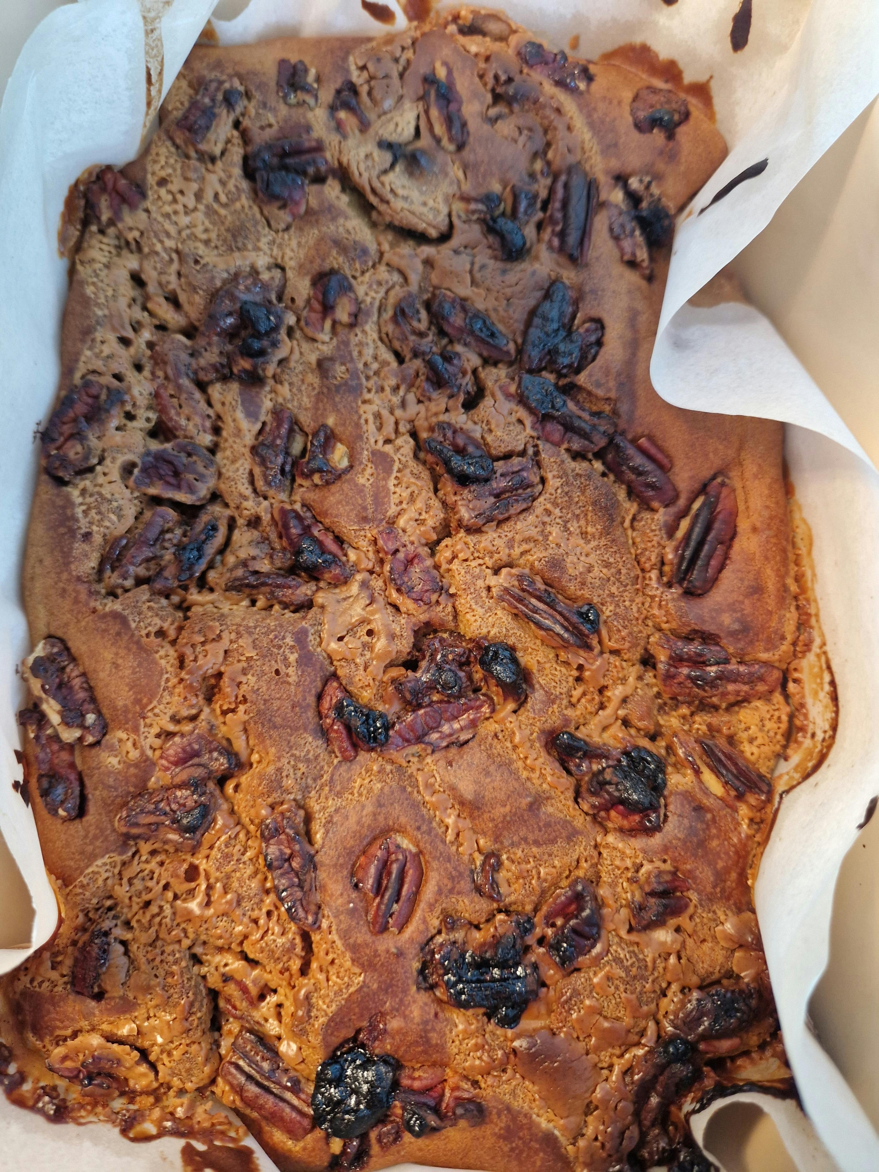 ein Brötchen mit Pekannüssen und Kirschen auf weißem Papier