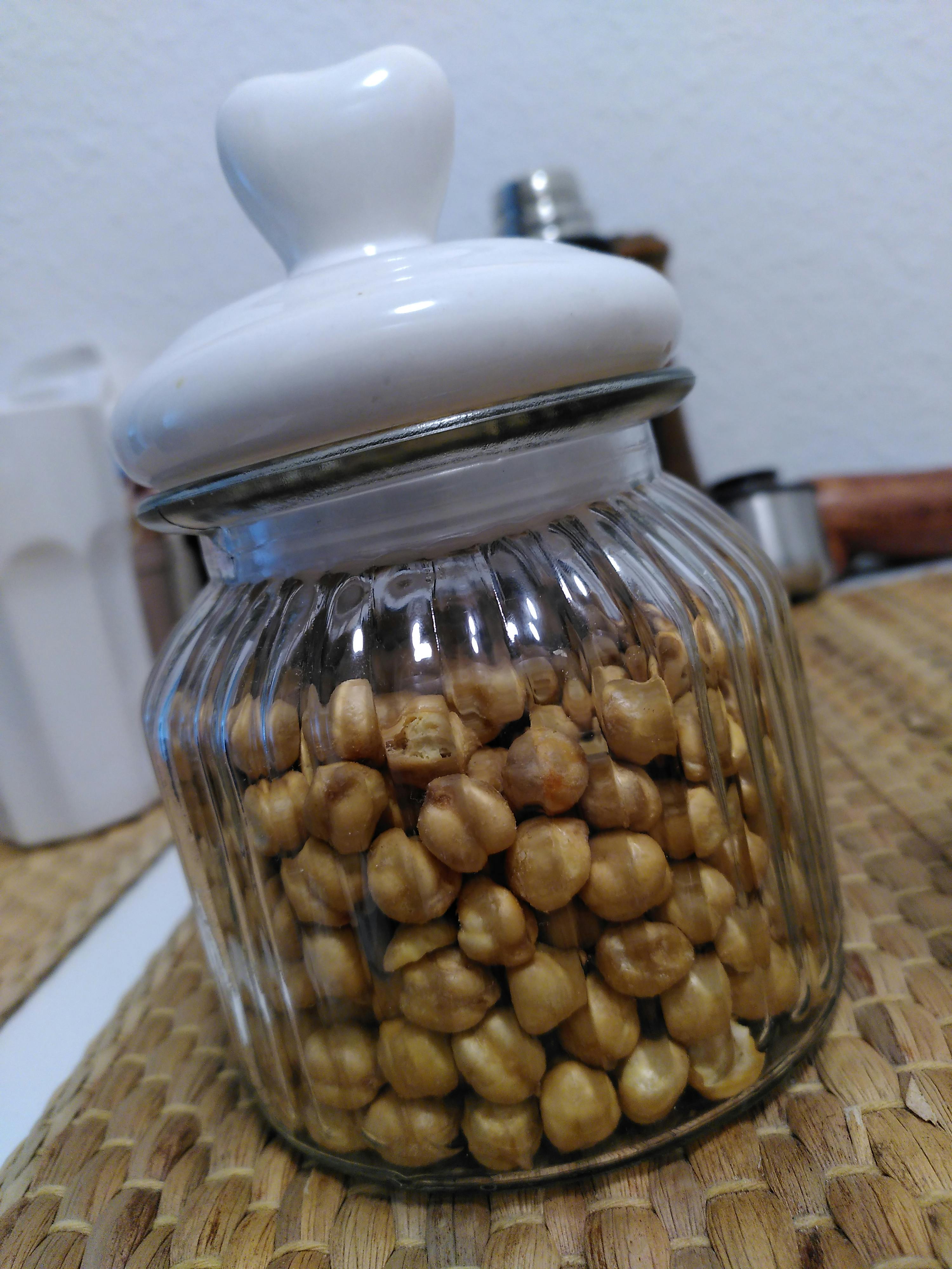 un barattolo di vetro pieno di ceci con un coperchio bianco