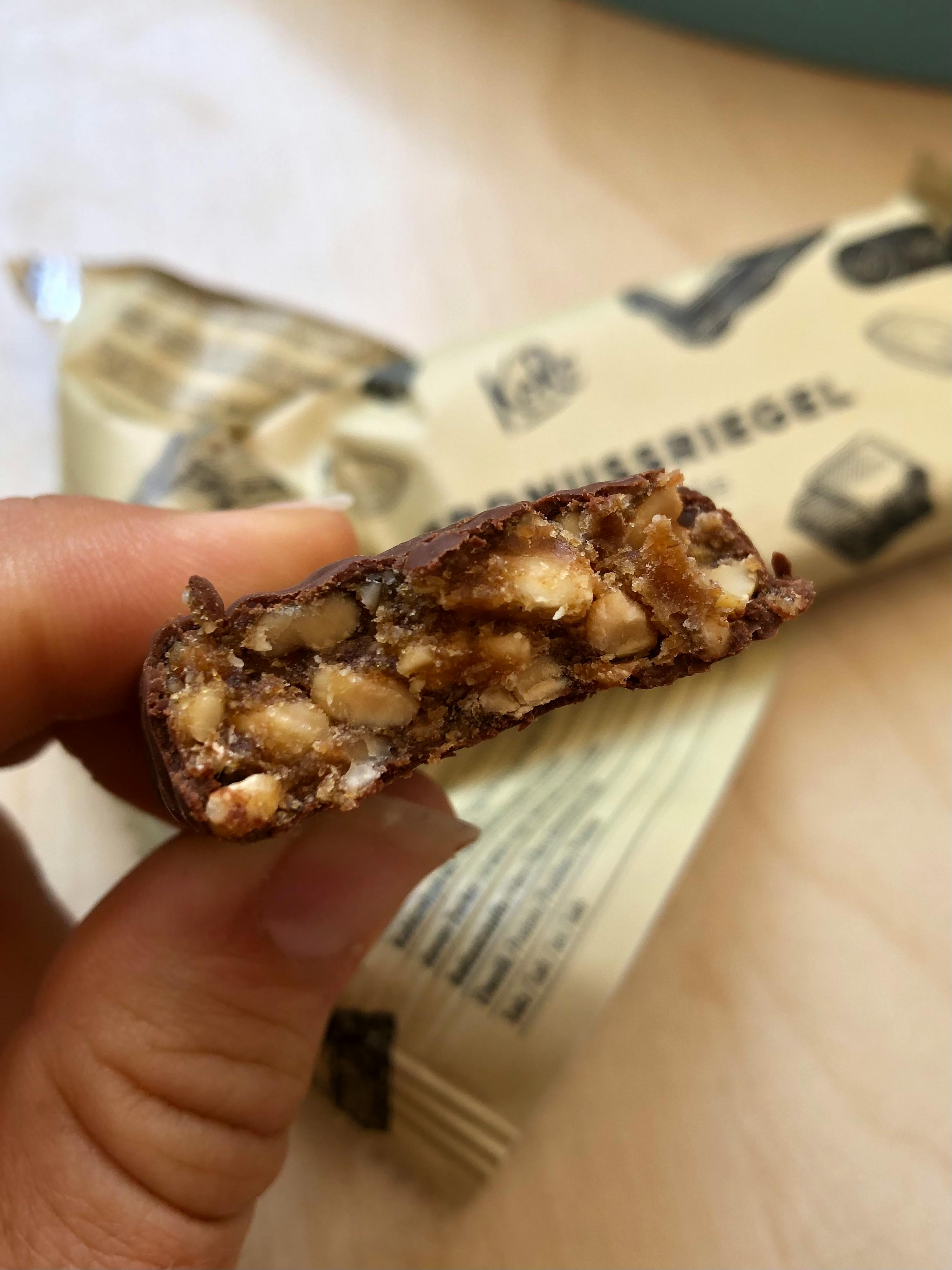 une personne tient une barre de chocolat avec une bouchée sortie
