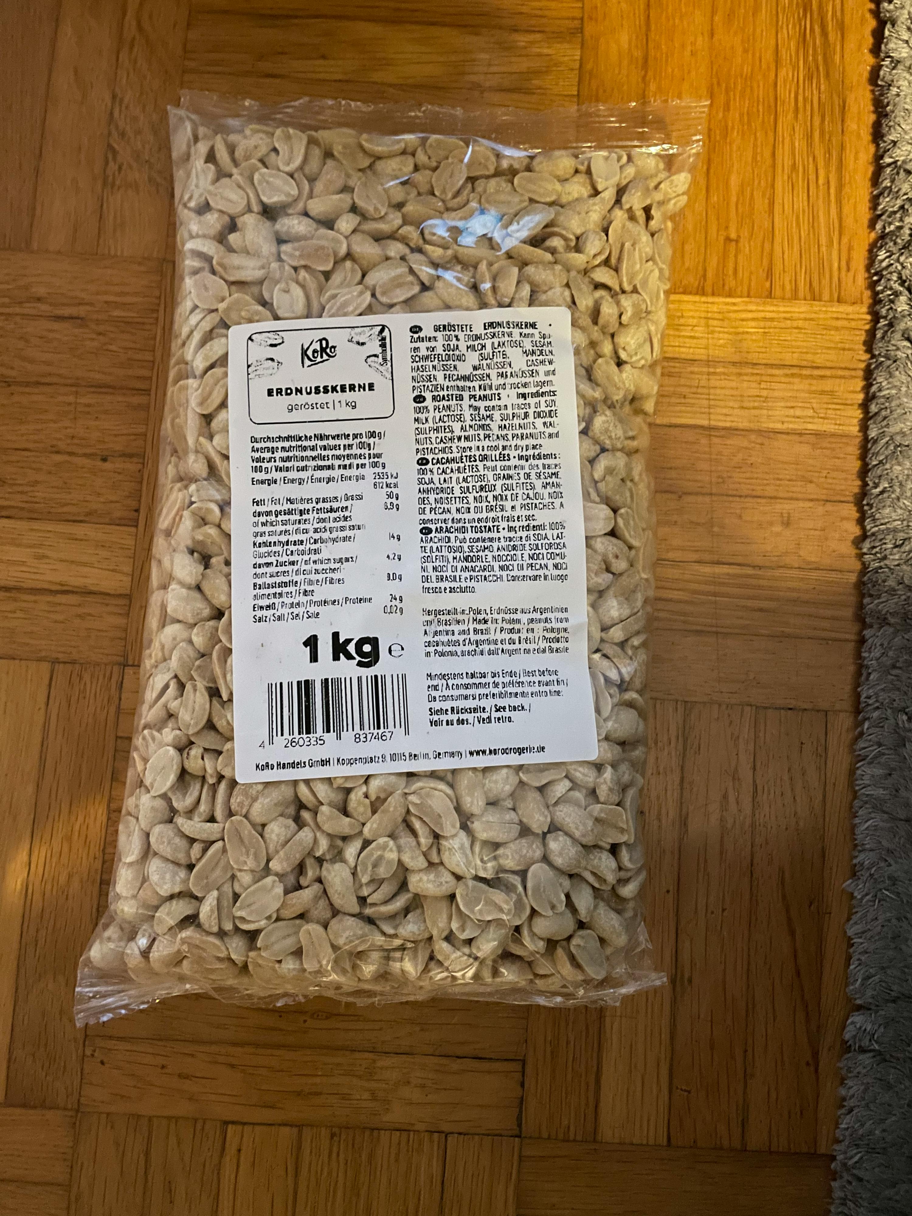 un sac de cacahuètes posé sur un plancher en bois