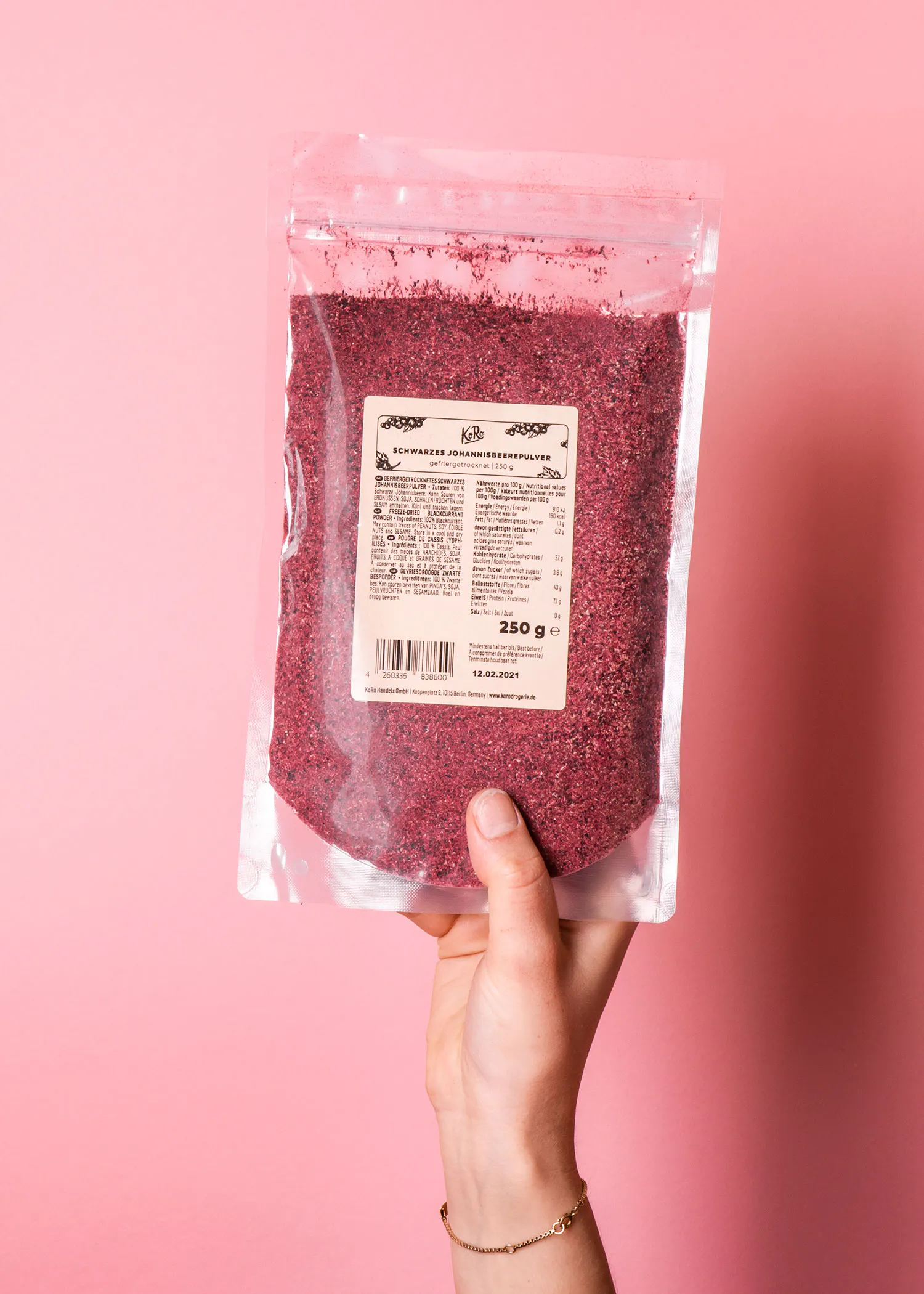 une personne tient un sac de poudre de framboise