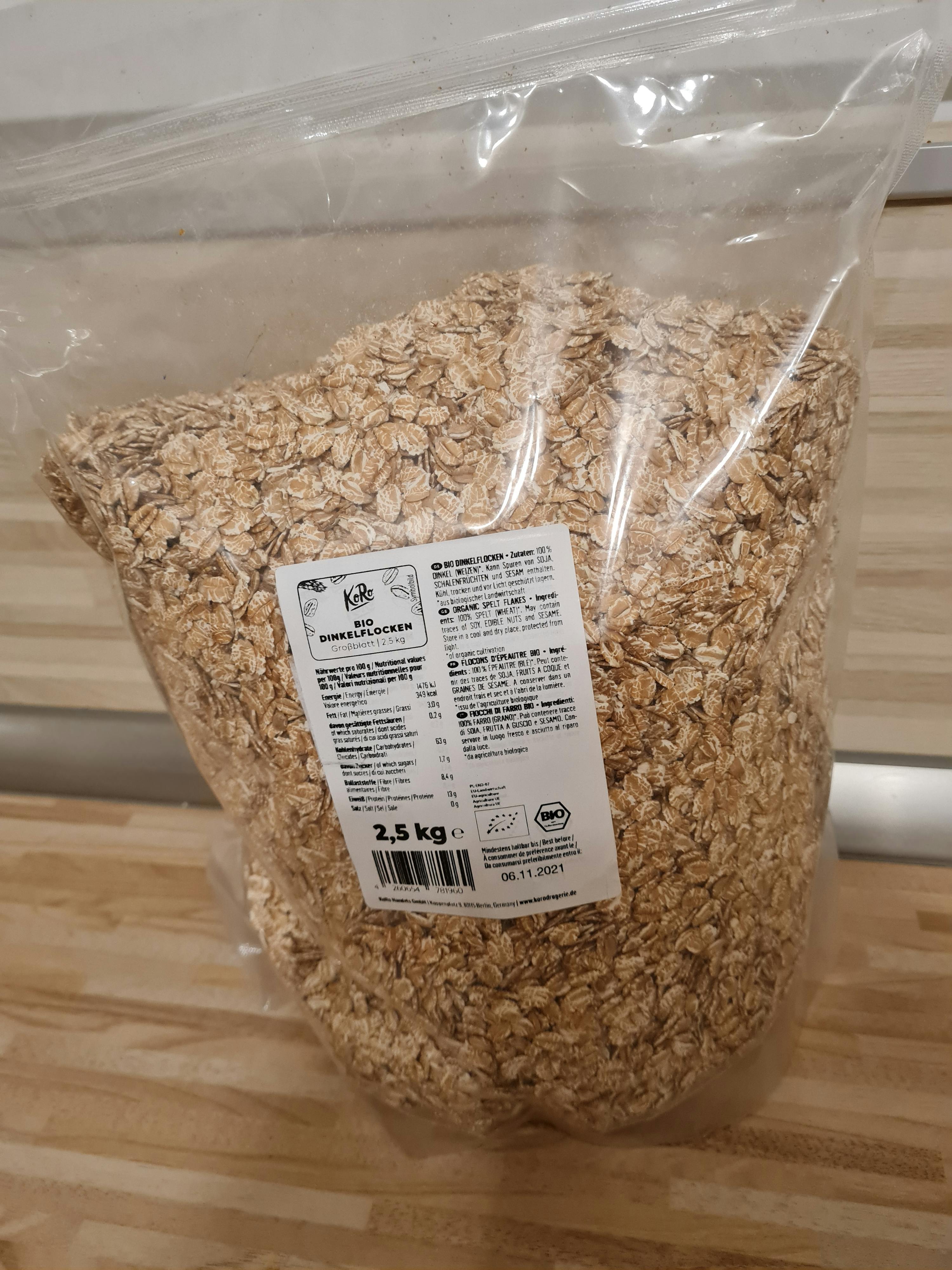 eine Plastiktüte mit Haferflocken steht auf einem Holztisch