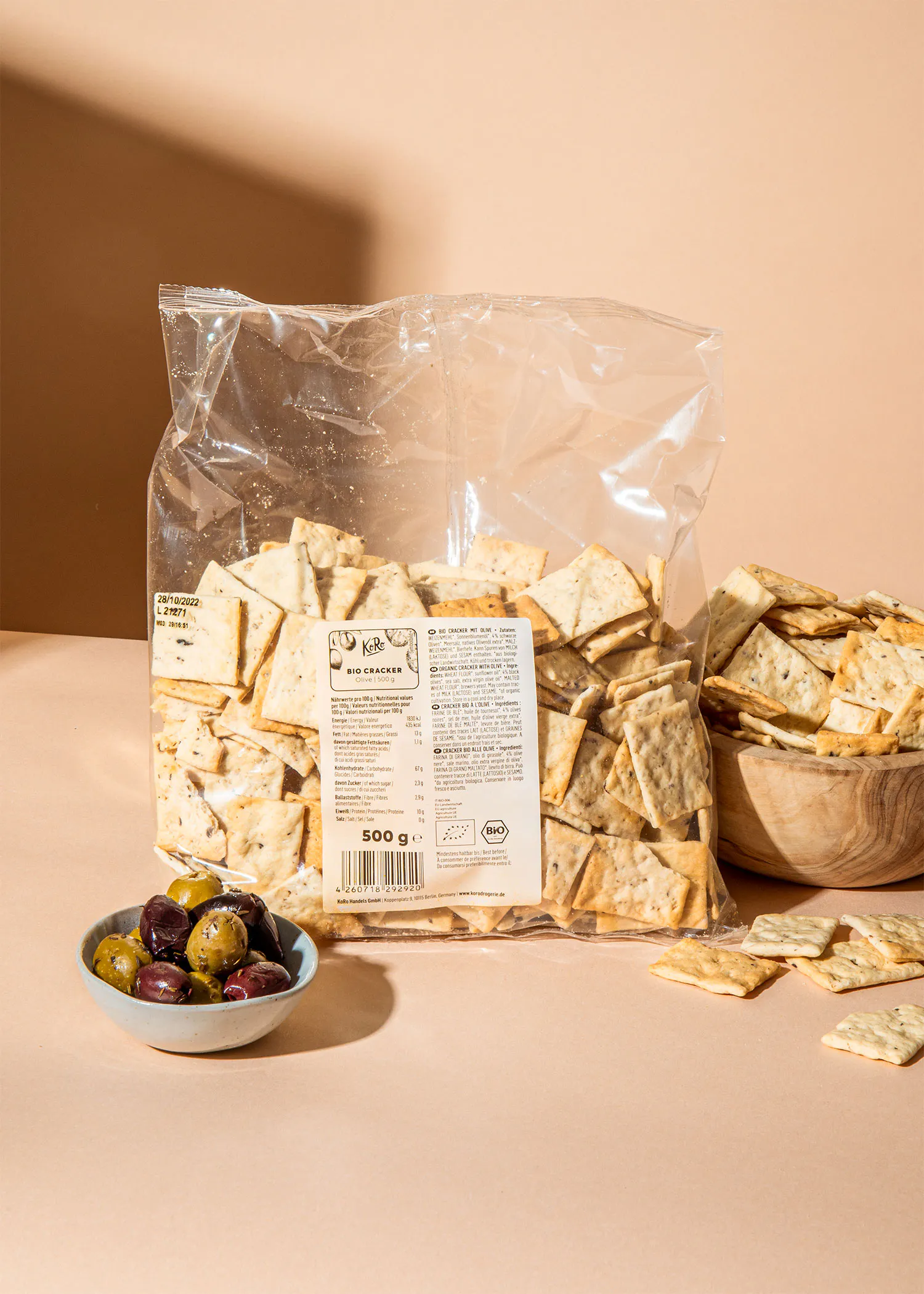 un sac de craquelins bio est posé à côté d' un bol d' olives
