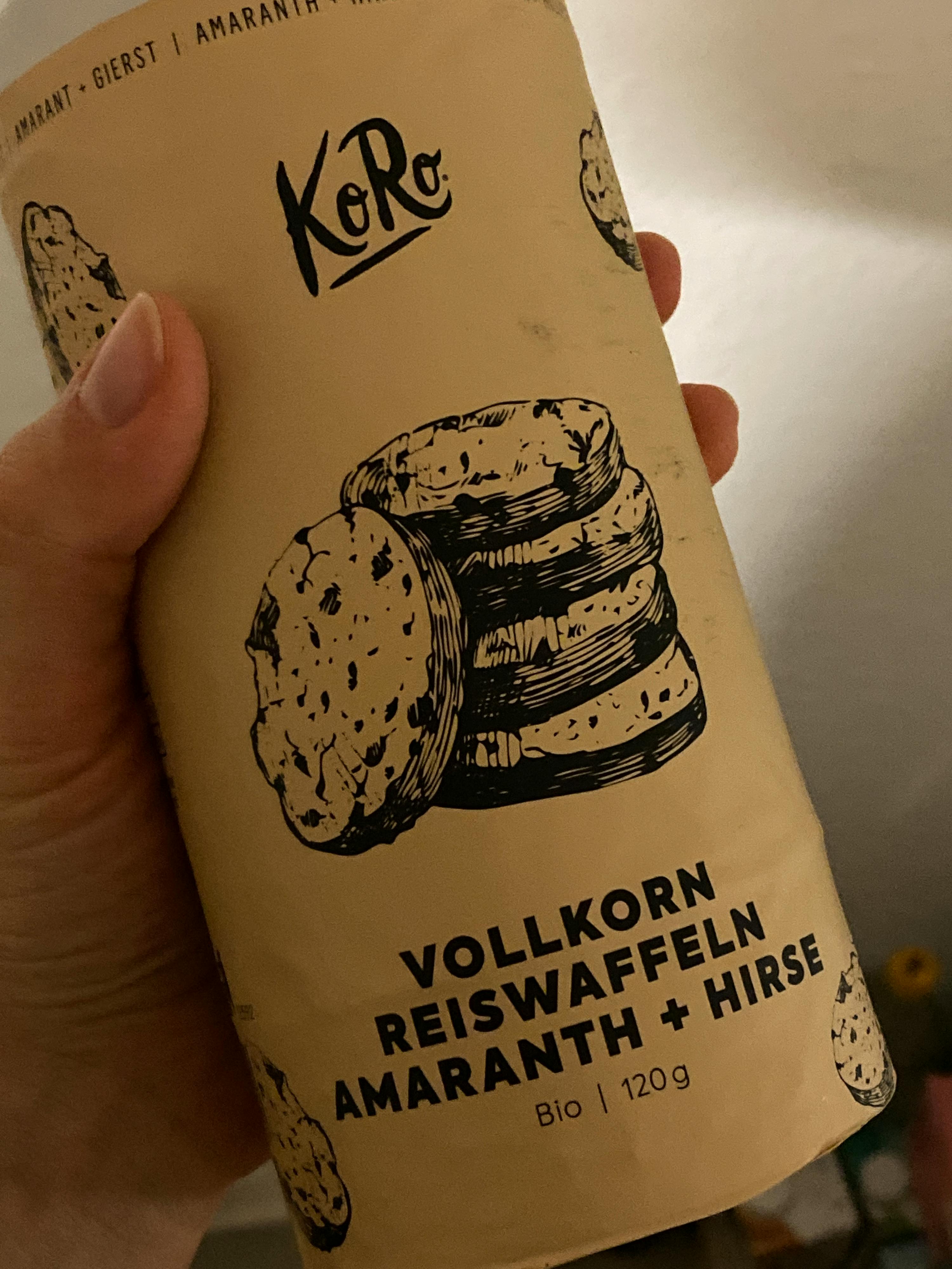 una persona tiene in mano una scatola di vollkorn reiswaffeln amaranth + hirse