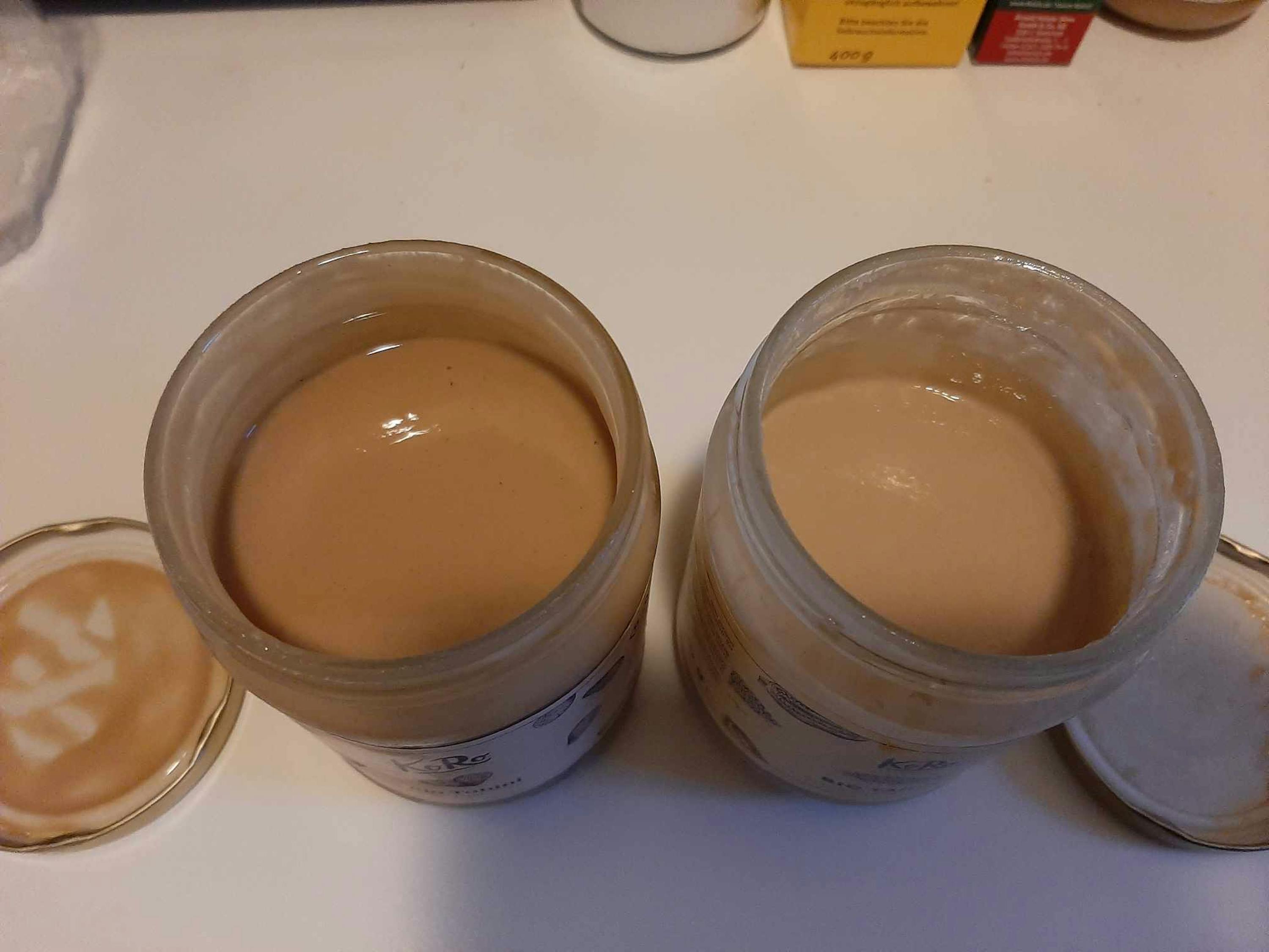 two jars of peanut butter sit on a table