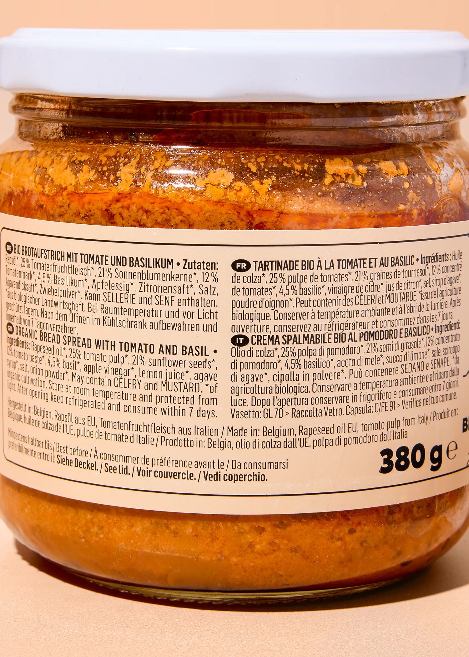 etichetta di un vasetto di crema spalmabile biologica al pomodoro e basilico con elenco degli ingredienti e informazioni sul prodotto in diverse lingue.