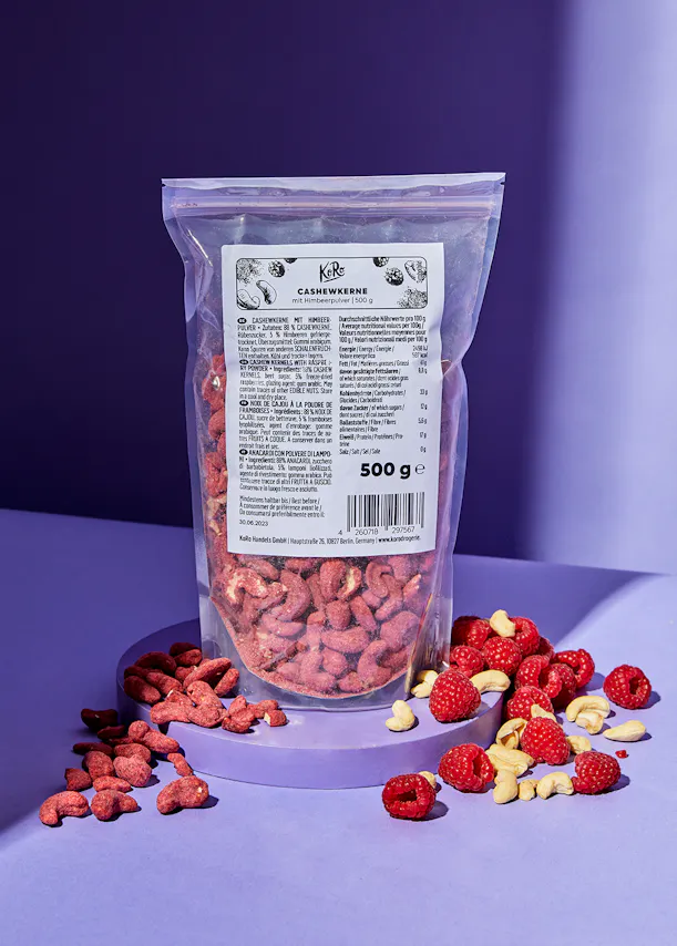 eine Plastiktüte mit cashewkernen und Himbeeren auf einem Tisch