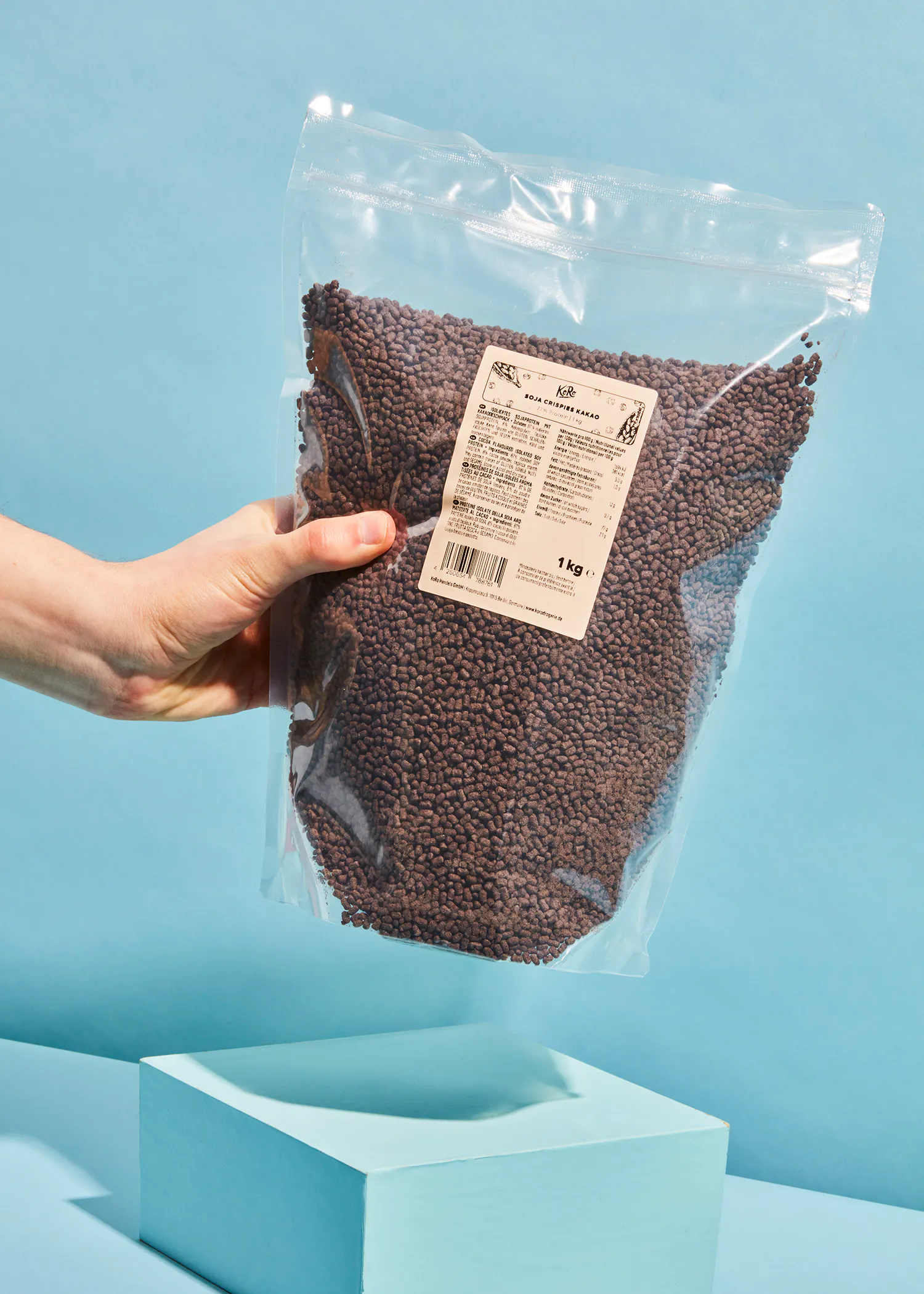 une personne tient un sac en plastique rempli de granulés de chocolat