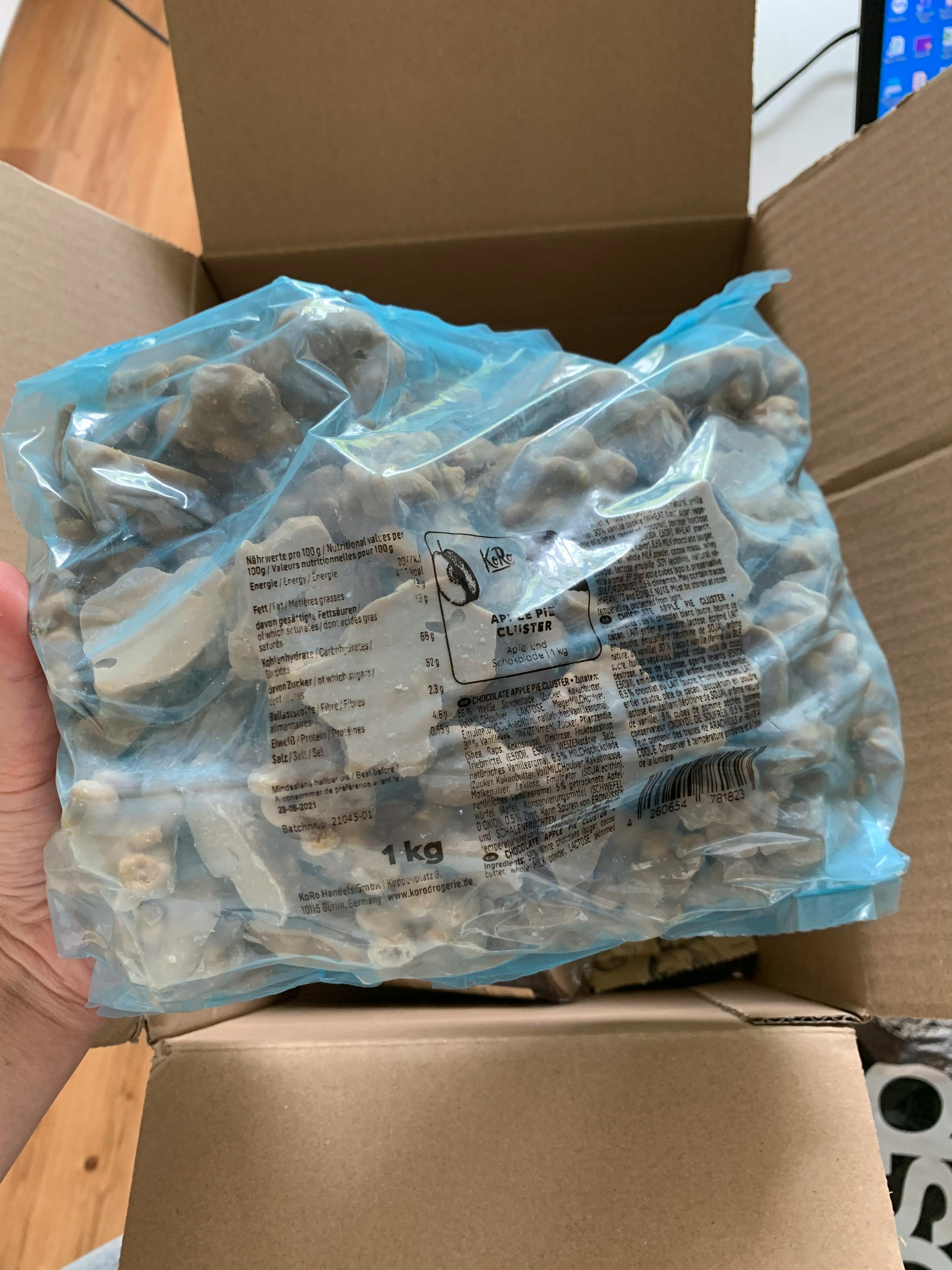 une personne tient un sac de noix dans une boîte