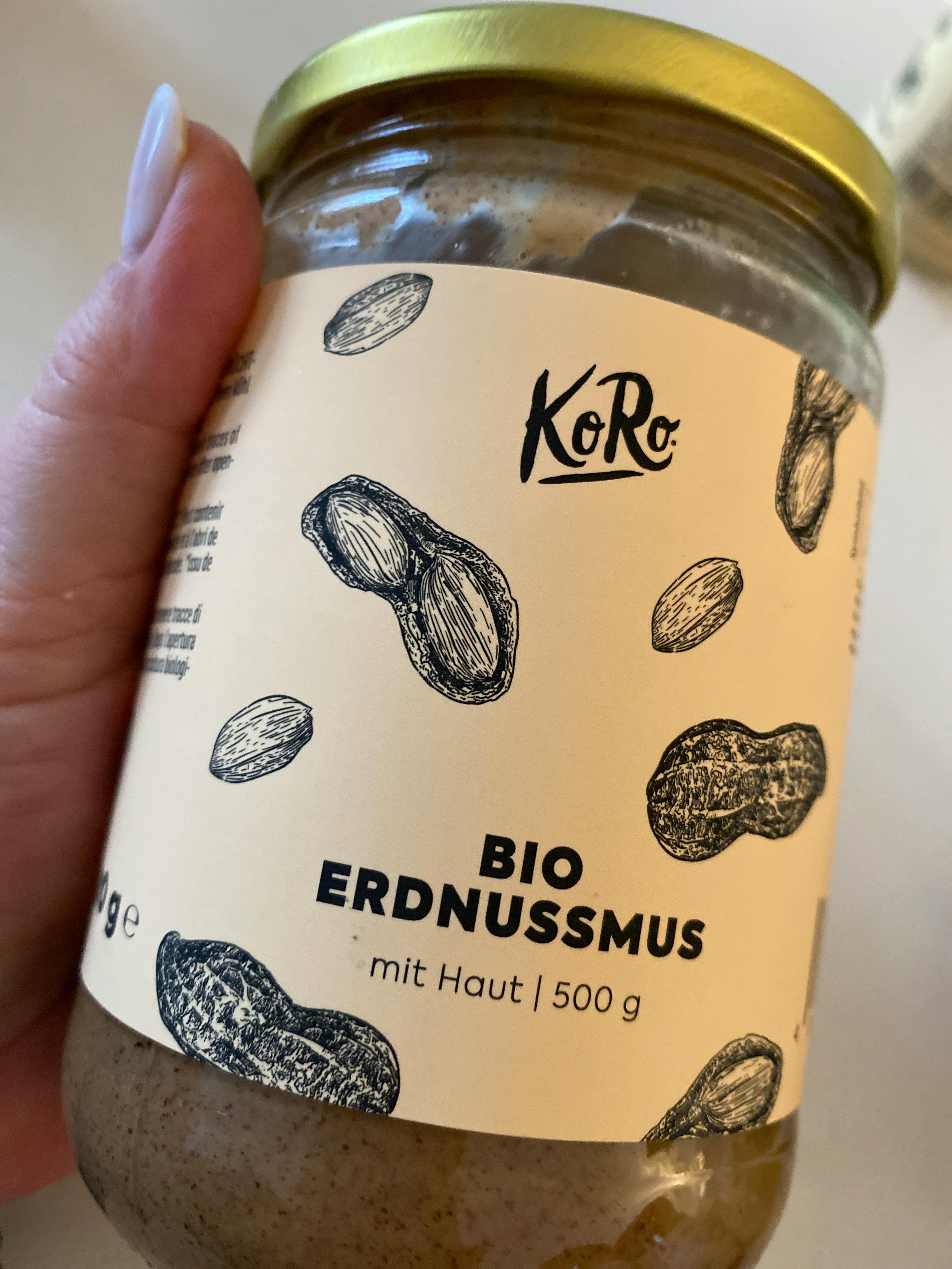 une personne tient un pot de beurre d' arachide bio