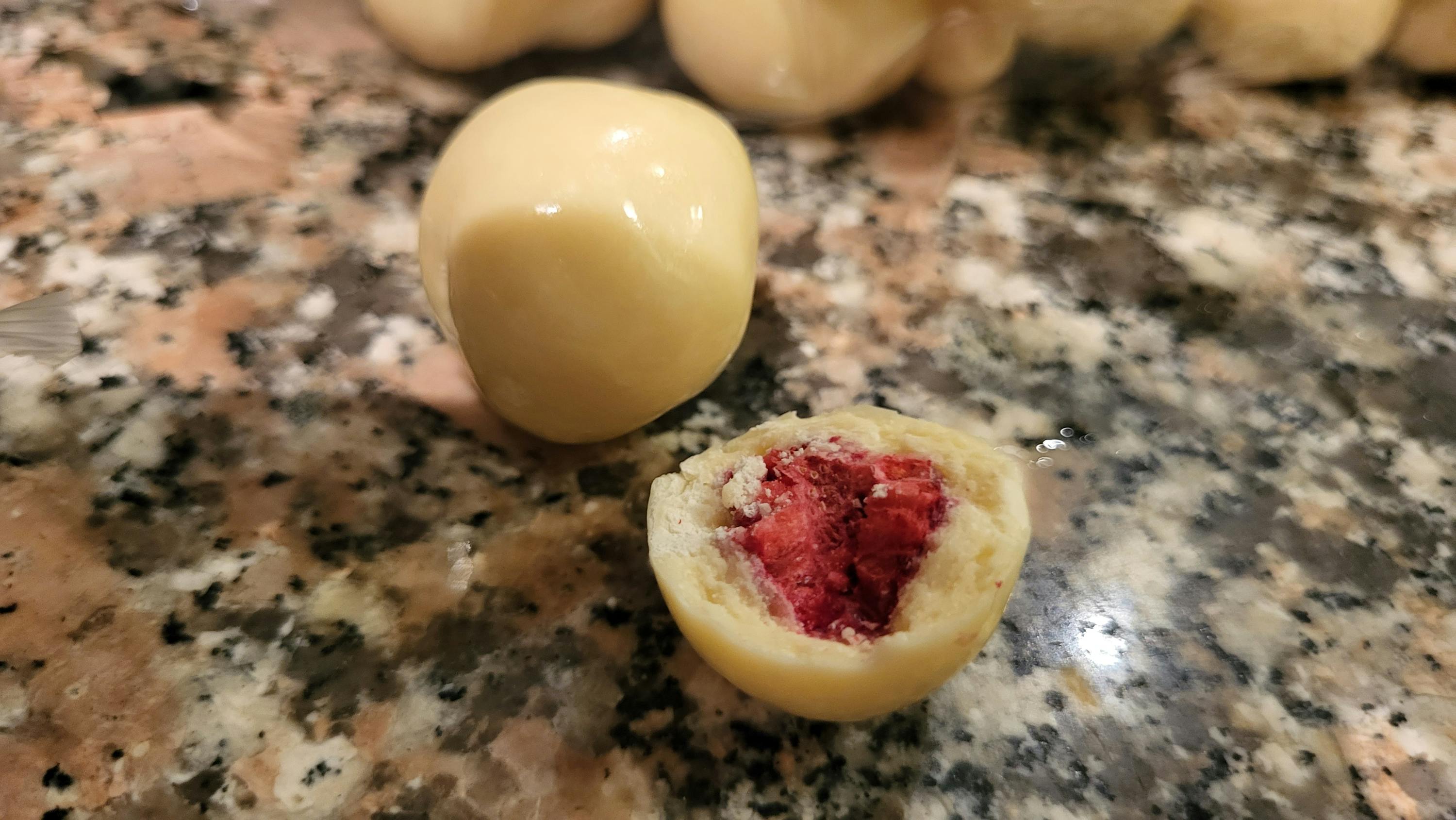 eine weiße Schokoladenkugel mit einem roten Herzen darin