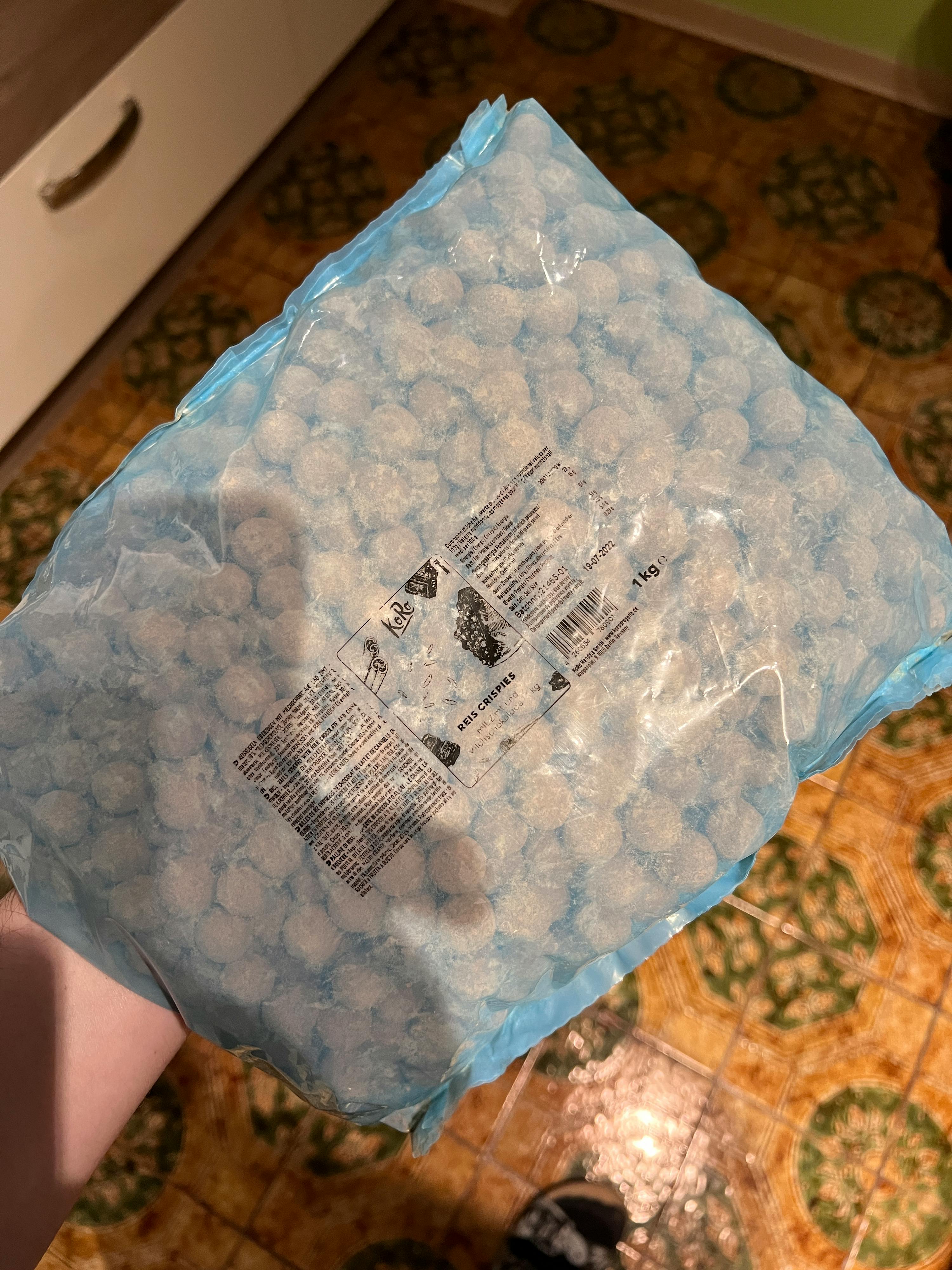 eine Person hält einen blauen Plastikbeutel mit weißen Marshmallows darin