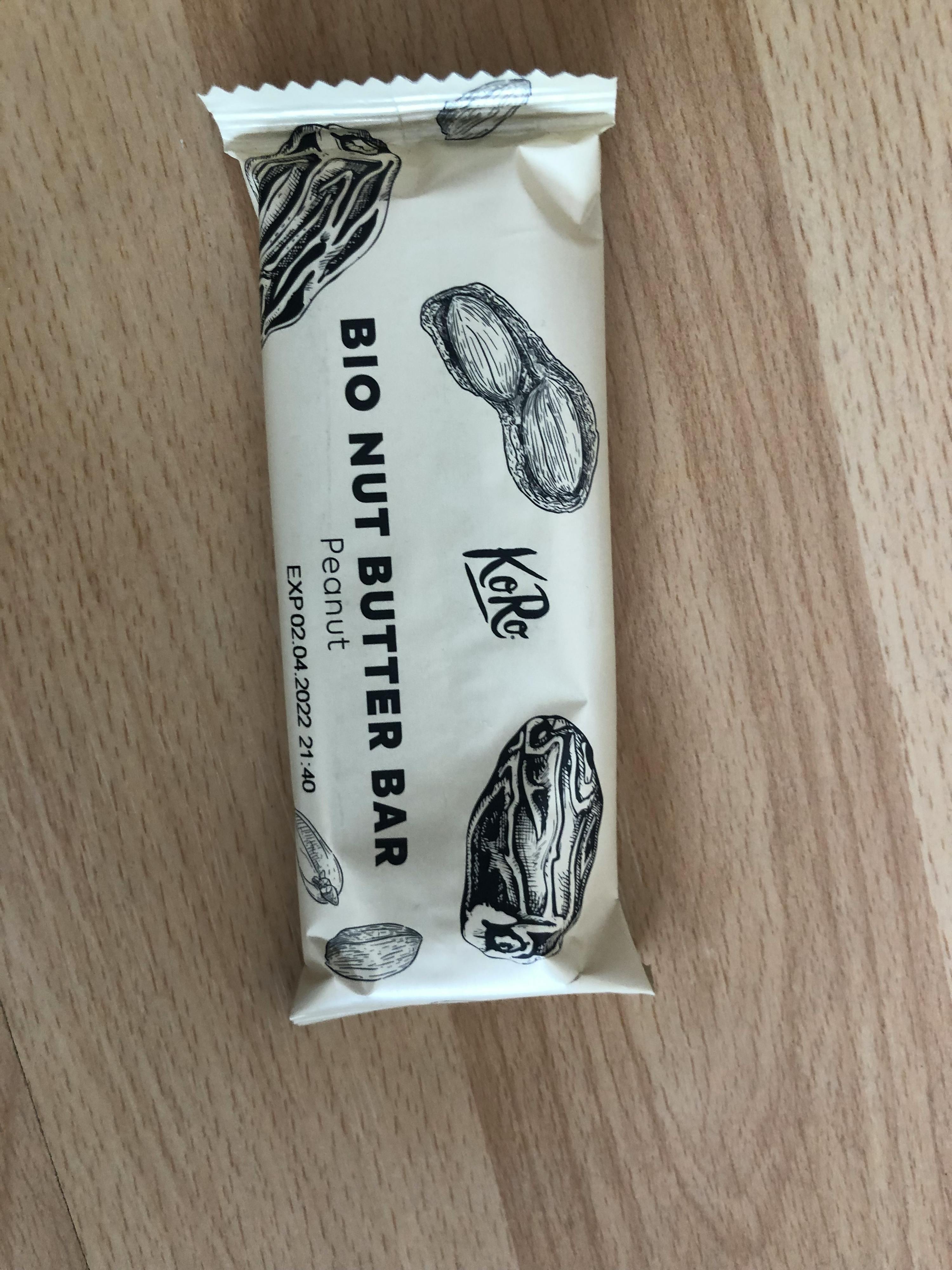 eine verpackte Bio-Nüssebutter-Bar mit Erdnussgeschmack liegt auf einem Holztisch
