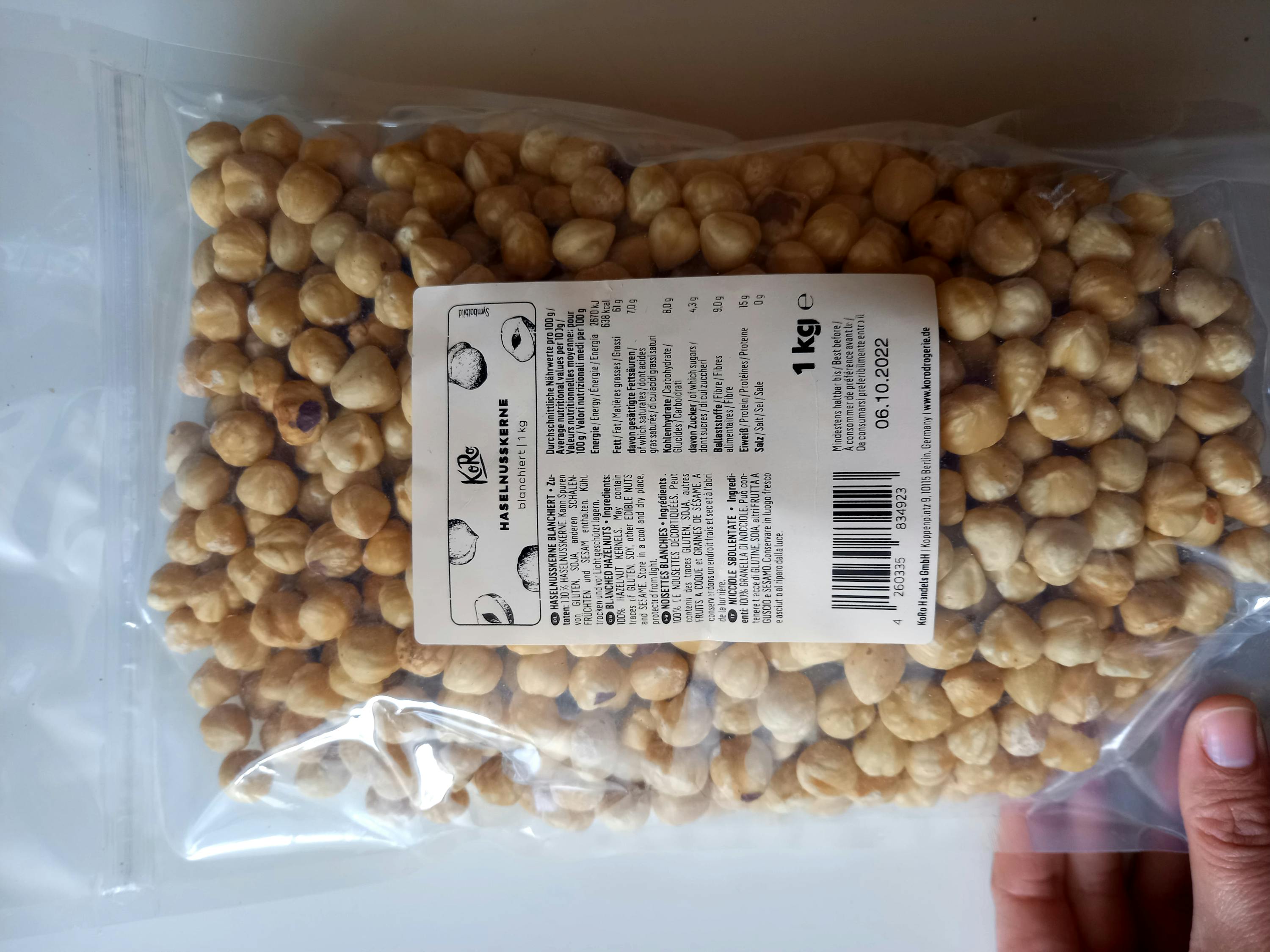 eine Person hält eine Tüte Haselnüsse in ihrer Hand