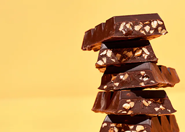 four pieces of chocolate are stacked on top of each other on a yellow background