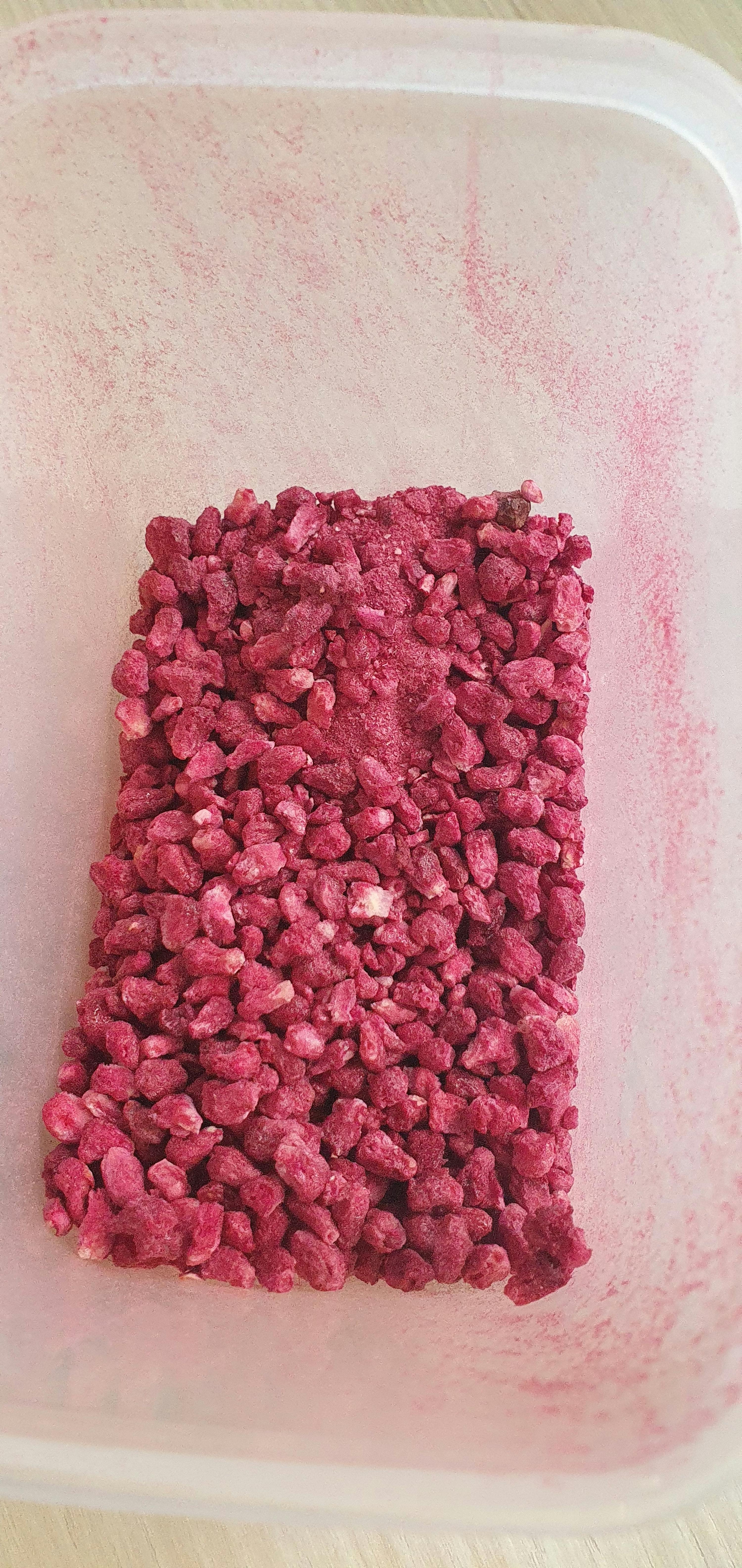 a plastic container filled with pink rice nuggets