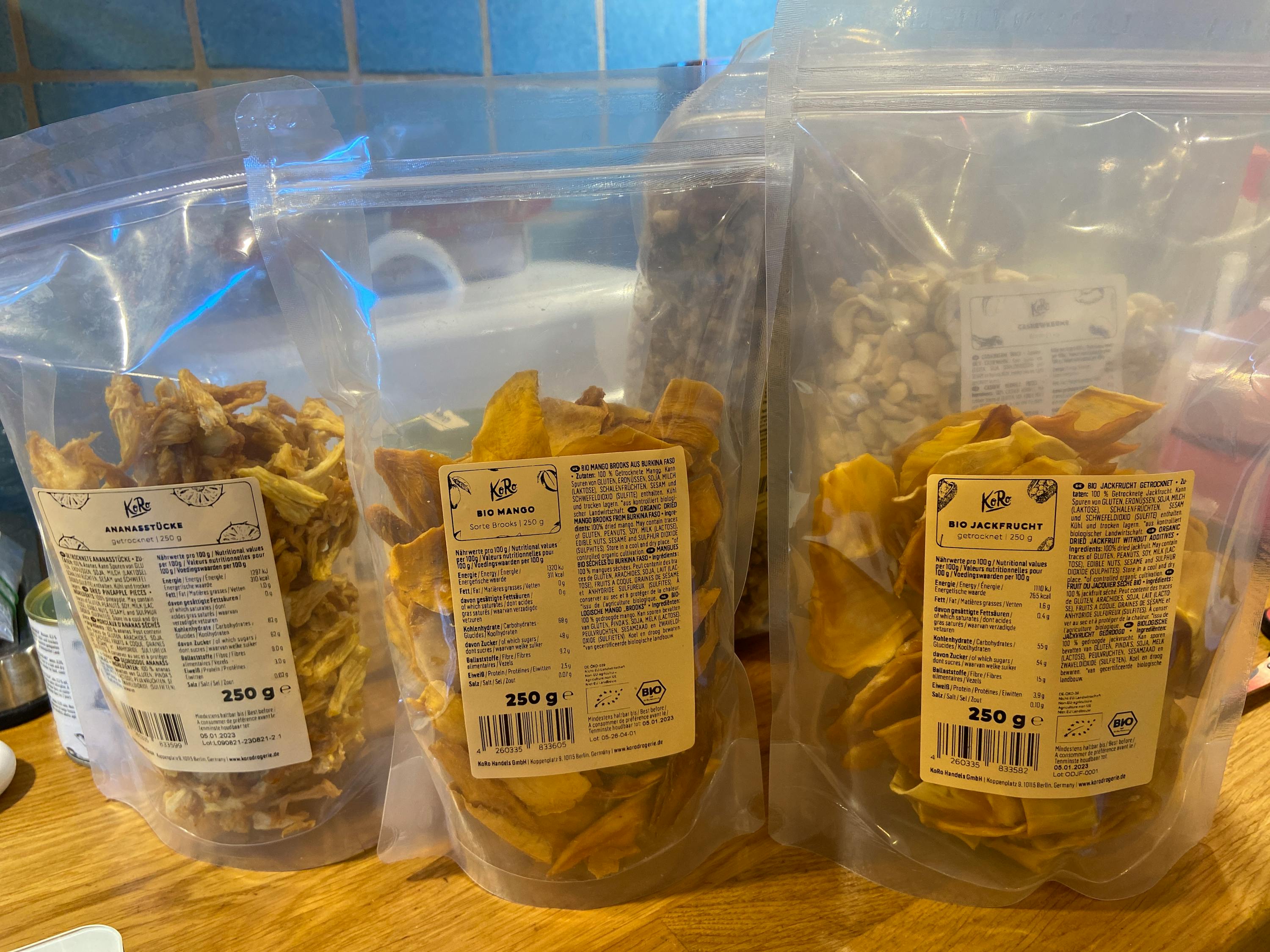 quattro sacchetti di frutta secca sono seduti uno accanto all'altro su un tavolo